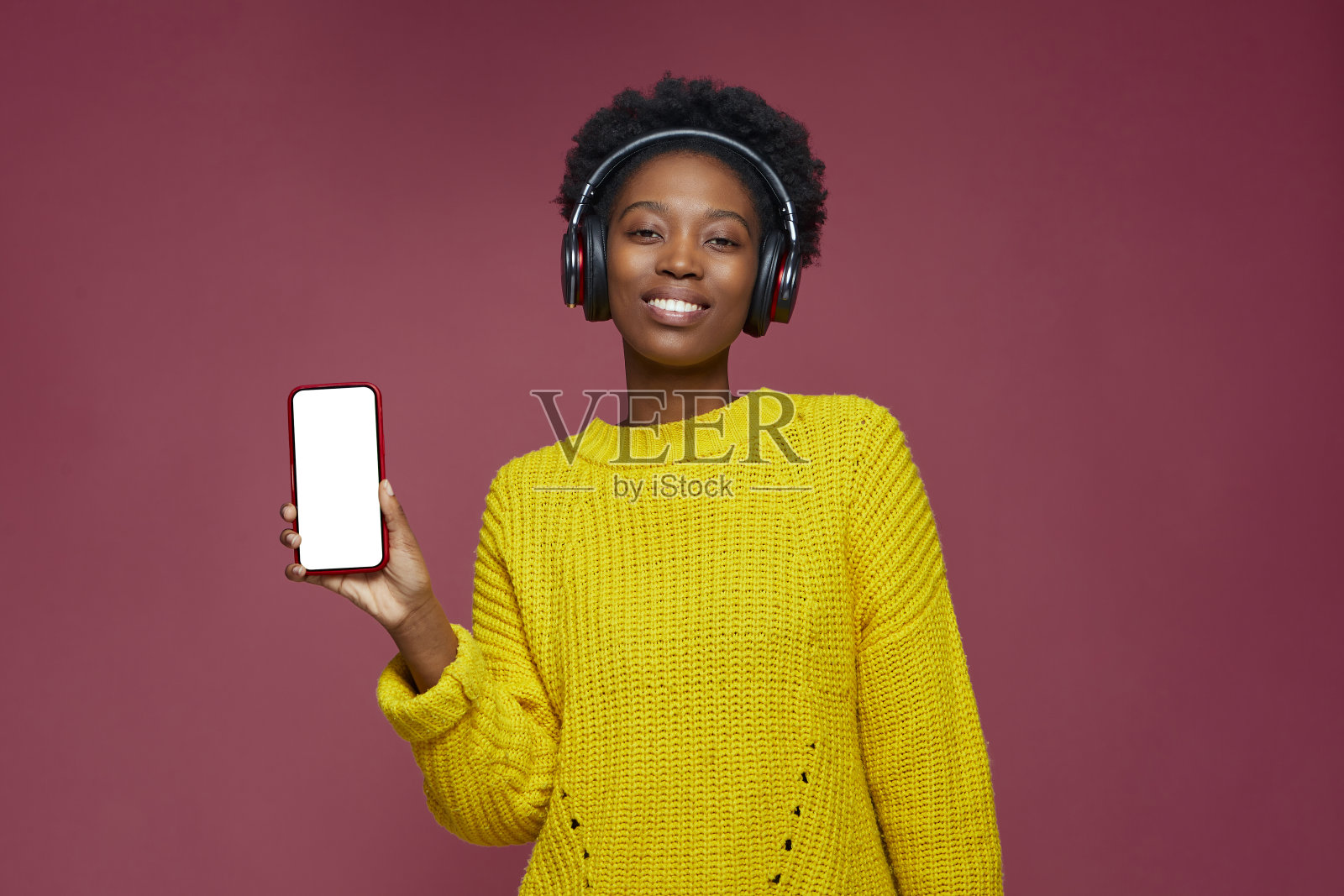 现代年轻的非洲裔美国妇女在耳机显示手机与模拟空白屏幕享受音乐应用程序照片摄影图片
