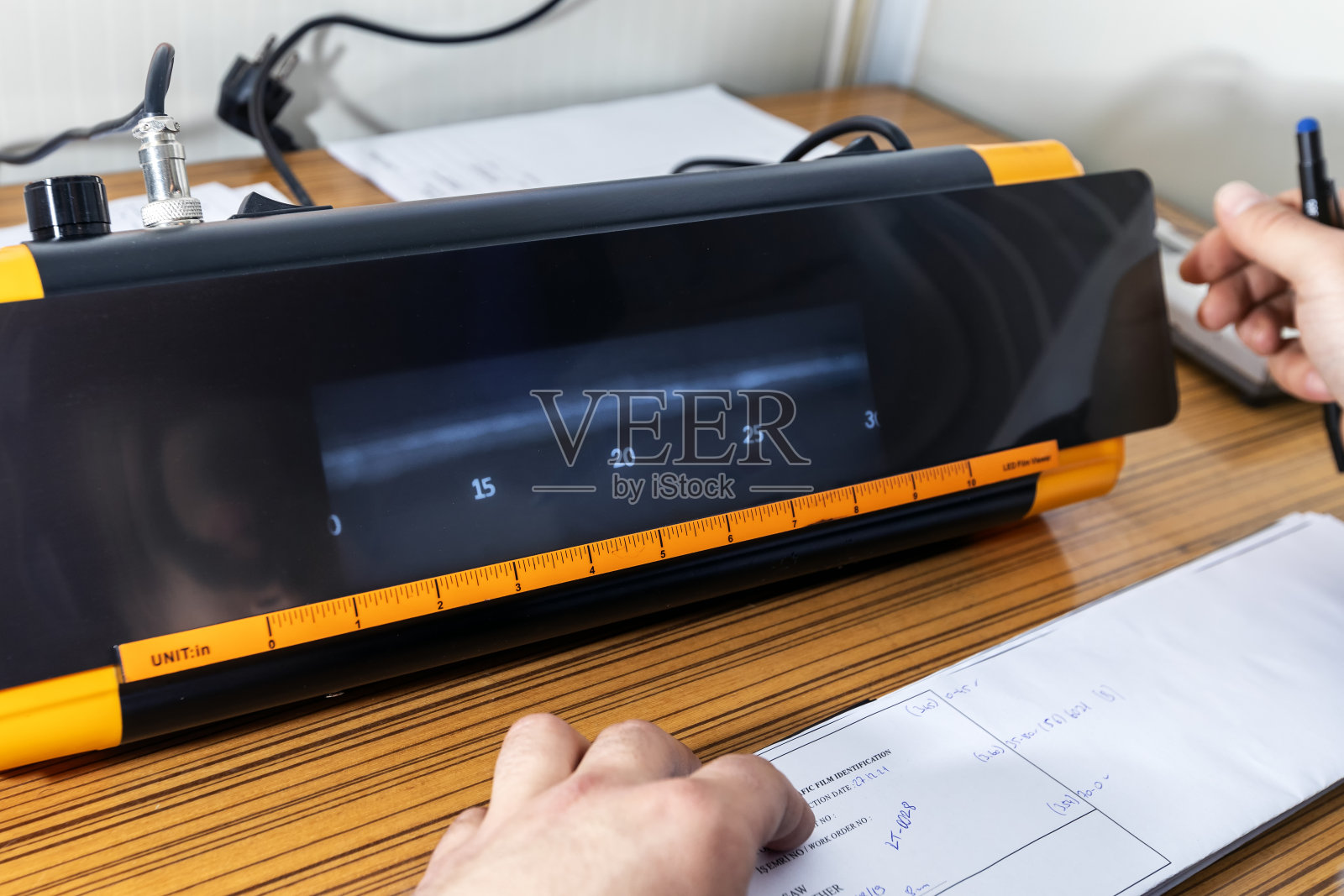 检查员正在复查管子焊缝的x光片。照片摄影图片