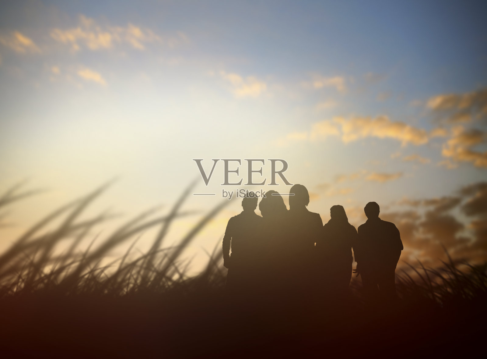 一群剪影的人在大自然中看着夕阳西下的天空照片摄影图片