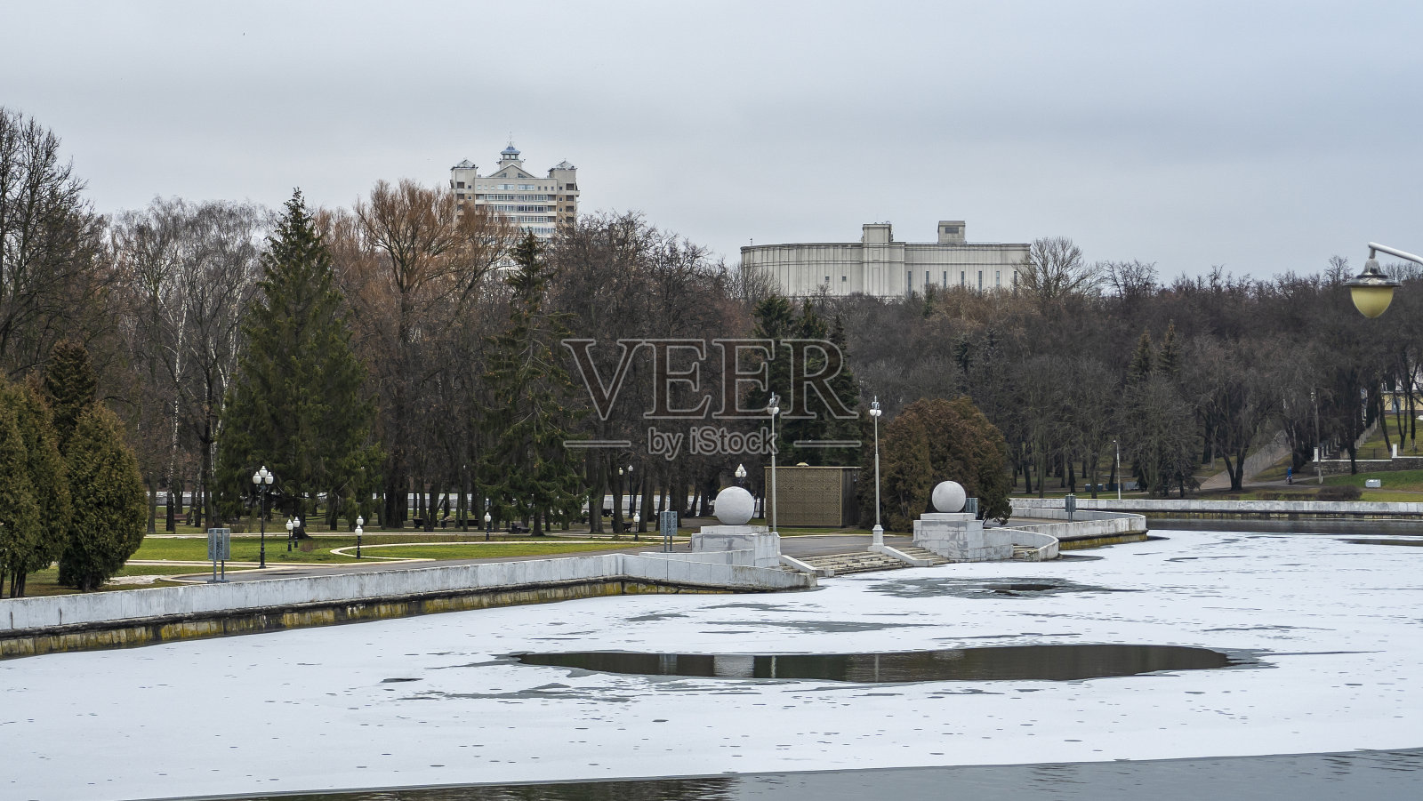 黑色的河水上结着薄冰。明斯克市中心第一次结冰。照片摄影图片