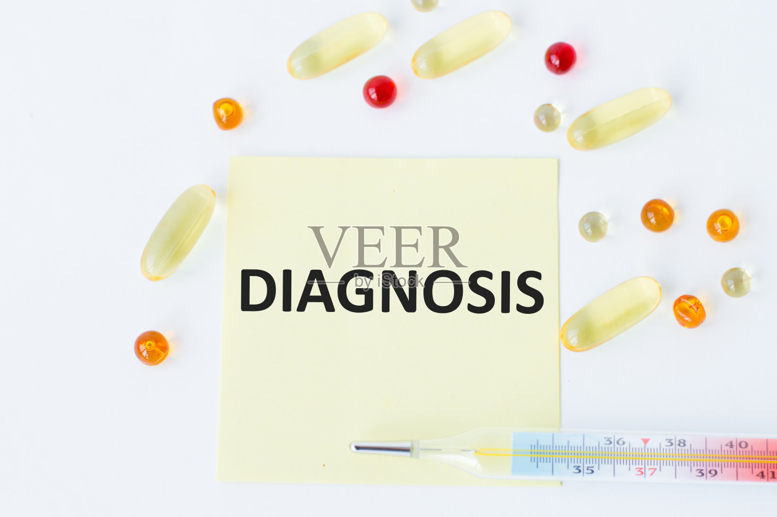 诊断文本在白色背景上的黄色贴纸上，旁边是散落的药片和温度计照片摄影图片