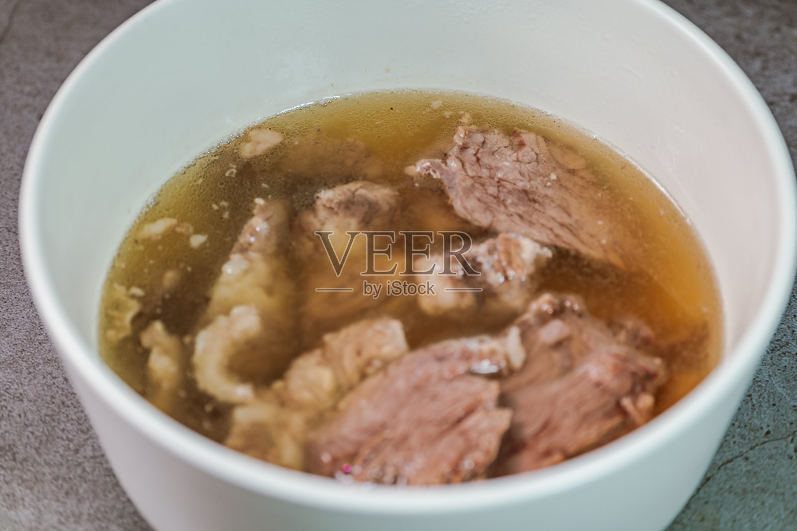 韩式牛肉排骨汤:牛肉排骨，用冷水浸泡去血，和白萝卜块一起炖至变软。清汤味道浓郁，嫩肉从骨头上脱落。(玻璃面条可能是广告照片摄影图片