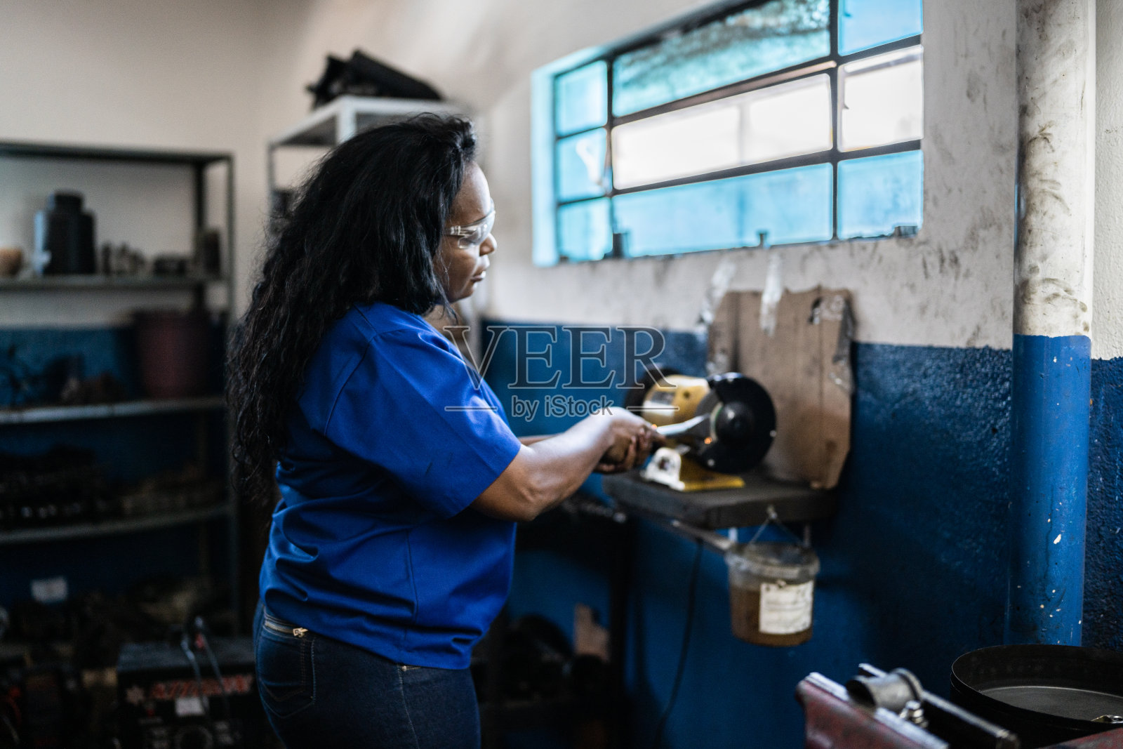 在汽车修理店修车的女人照片摄影图片