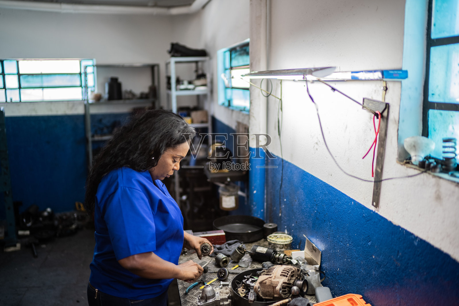 在汽车修理店修车的女人照片摄影图片