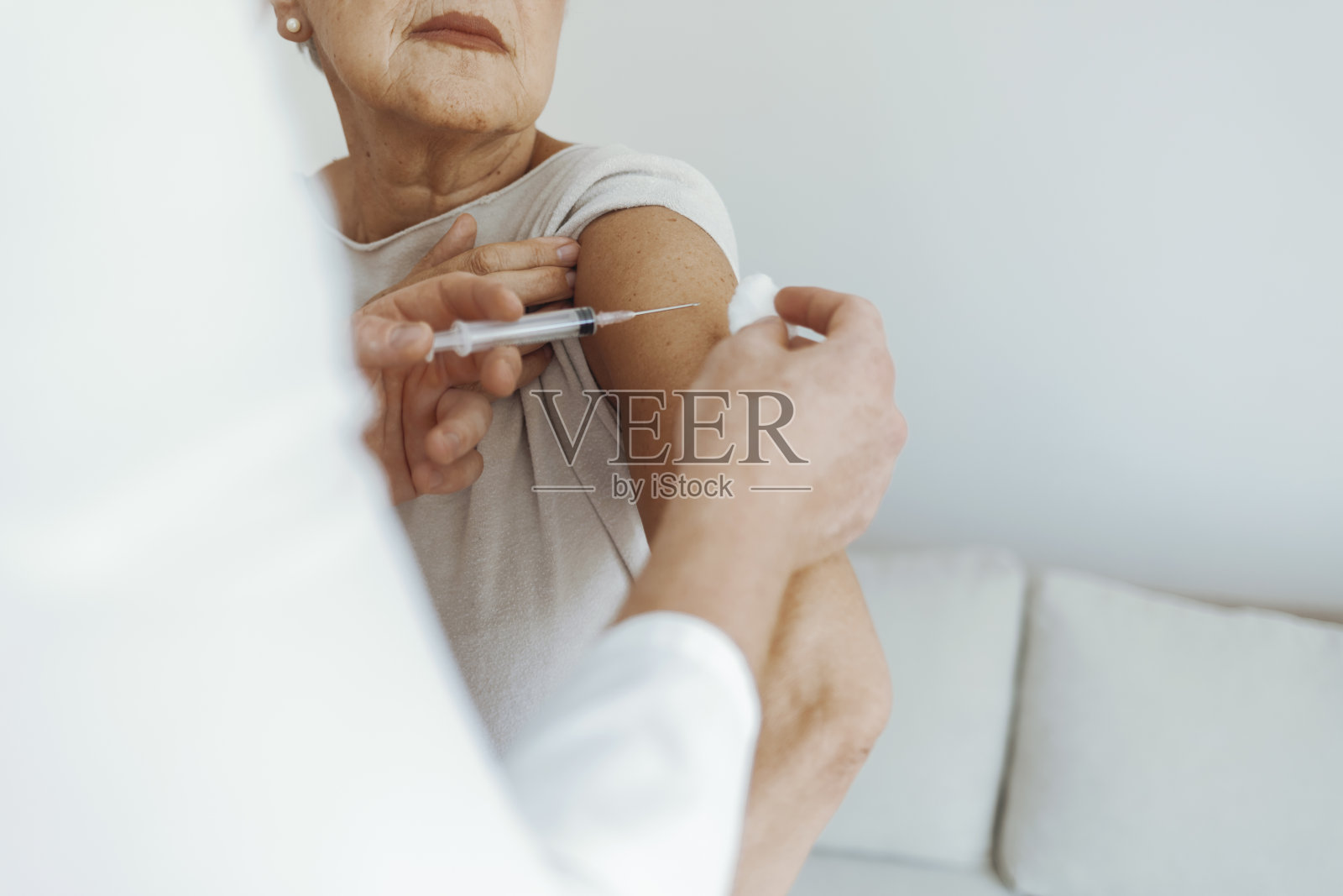 医生给老年病人接种疫苗。照片摄影图片