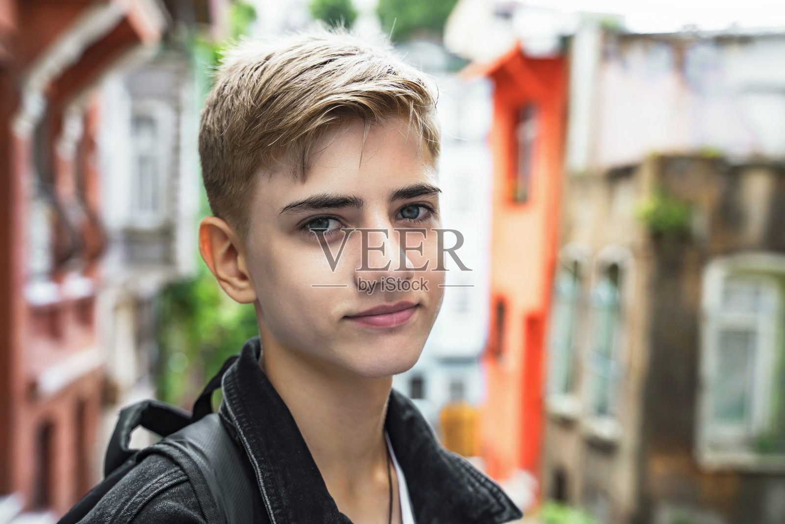 高中生的肖像，拿着书包在上学或放学回家的路上，微笑着看着镜头照片摄影图片