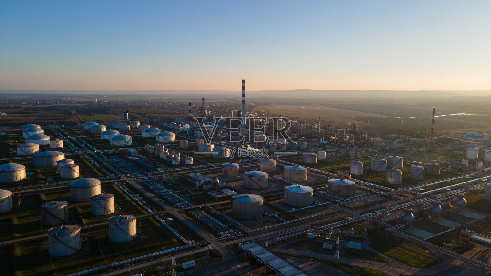日落时分的炼油厂，塞尔维亚。照片摄影图片