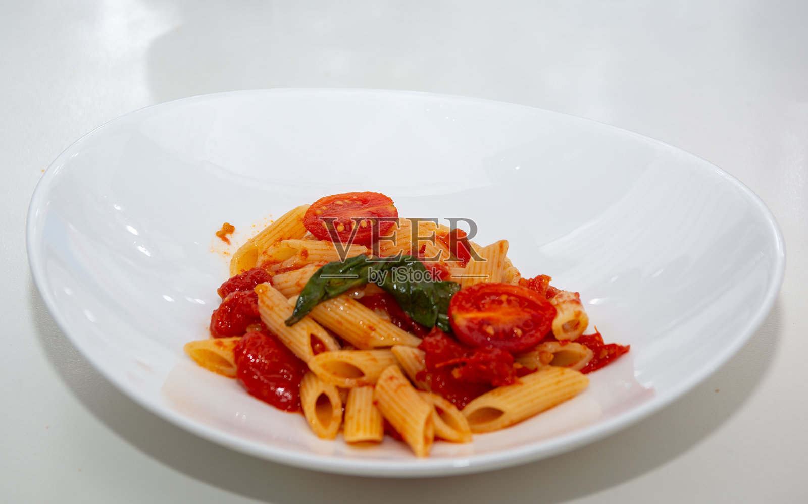 锅里放番茄和罗勒的意大利面照片摄影图片