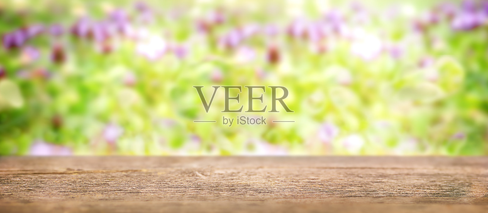 木桌的背景模糊的背景与盛开的草地照片摄影图片