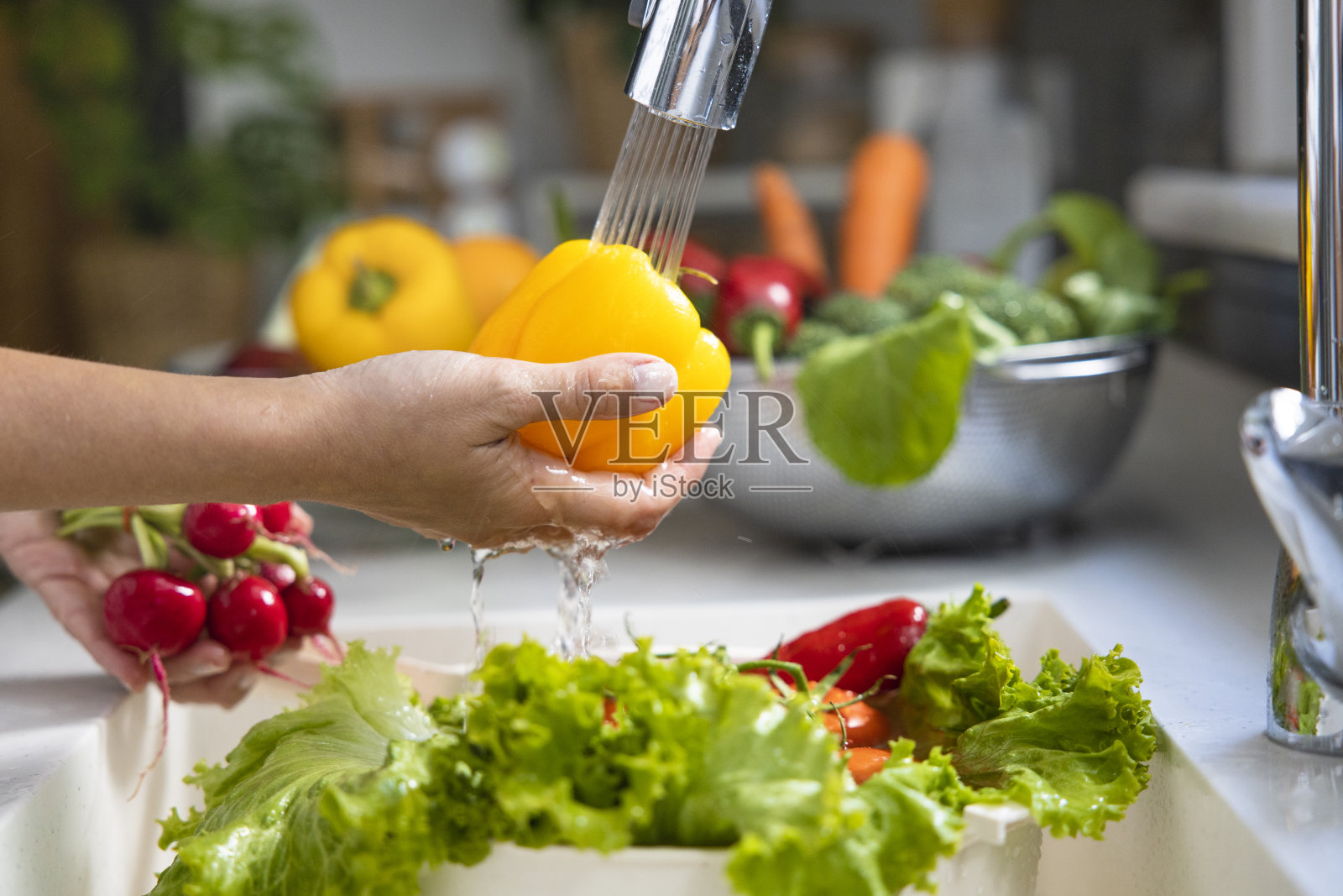 在厨房柜台上洗菜的女人照片摄影图片