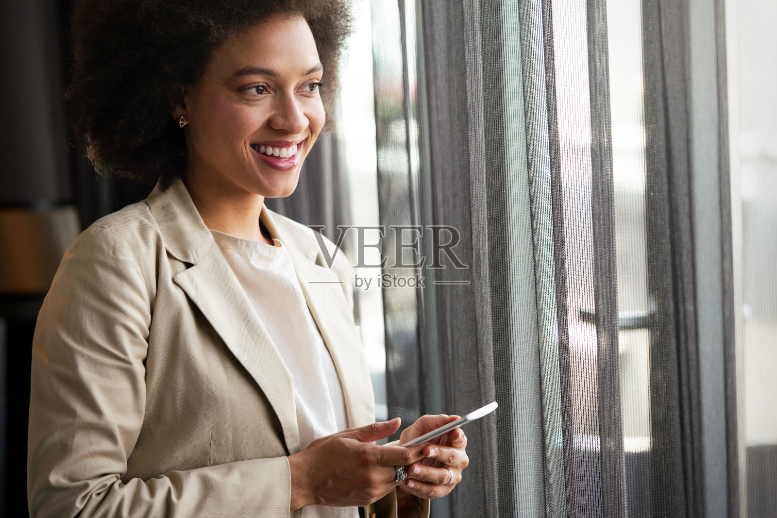 美丽的年轻非洲妇女的特写肖像与电话。照片摄影图片