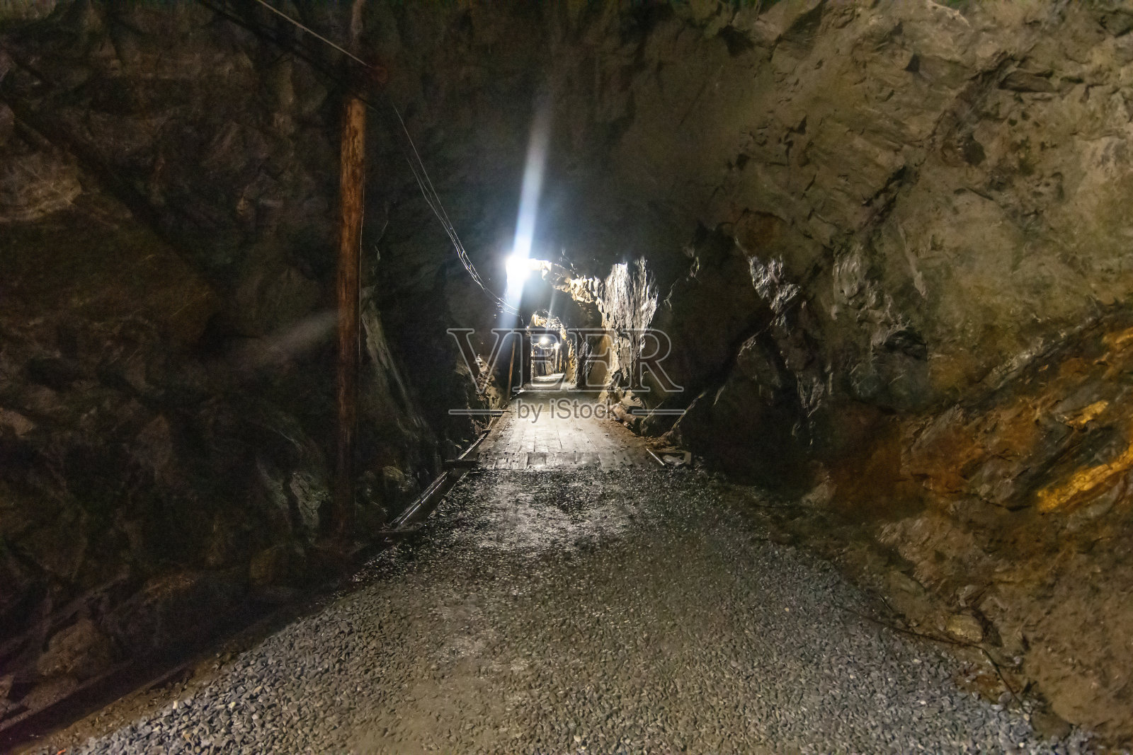 废弃的老煤矿内部。充满灰尘和生锈设备的危险隧道。金属支架照片摄影图片