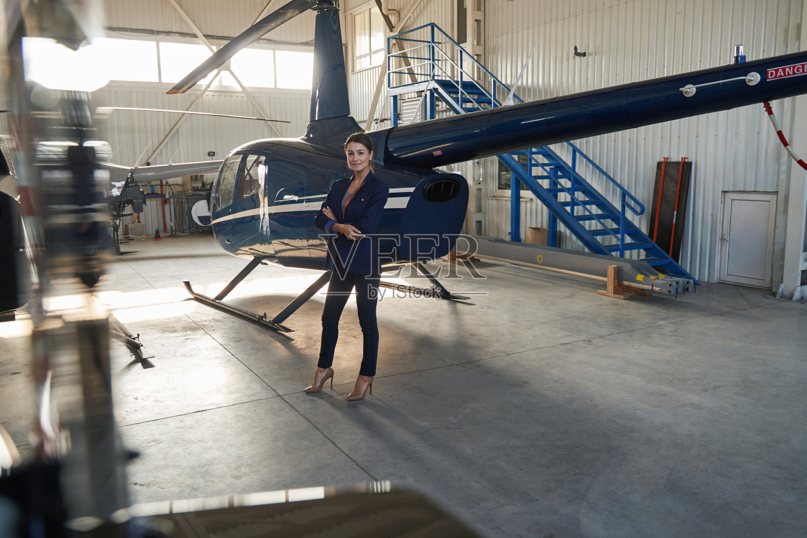 安详的女企业家站在停着的直升机旁照片摄影图片