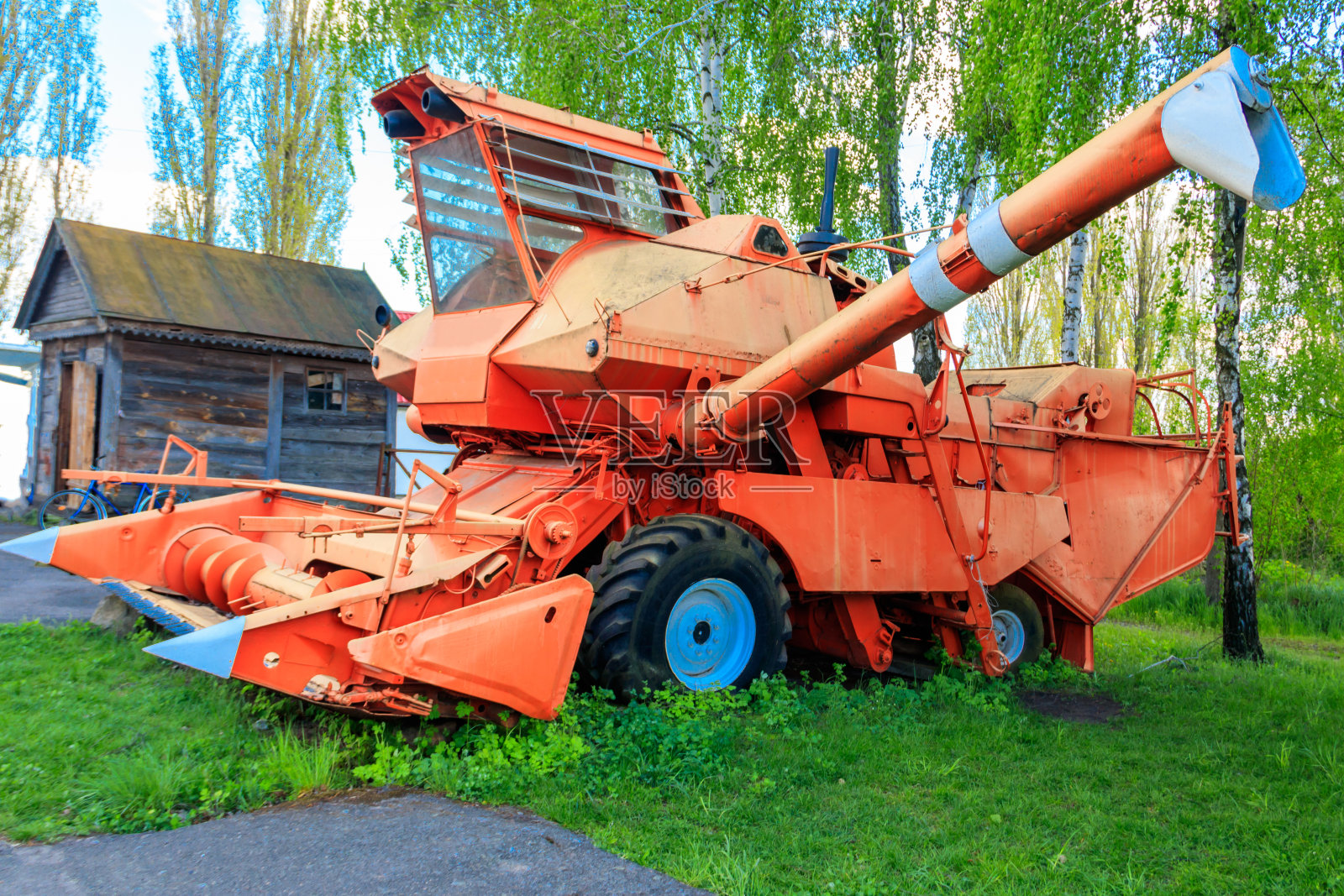 农家院子里的老式联合收割机。古老的农业机械照片摄影图片