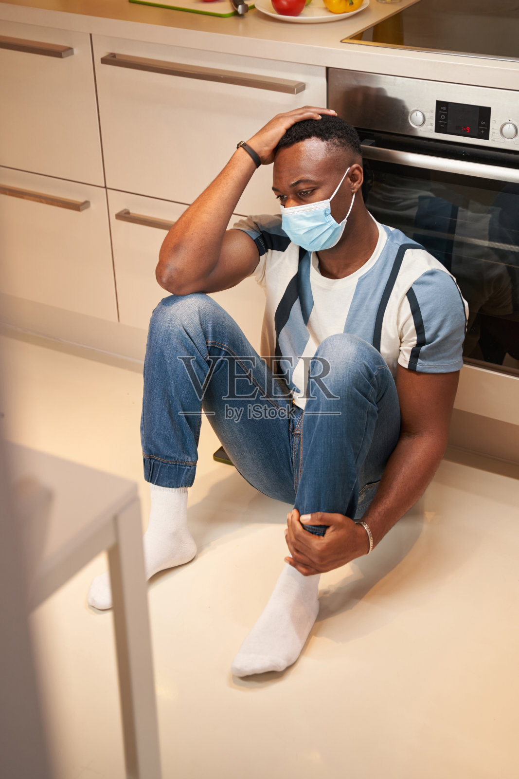 坐在厨房地板上沮丧的男人照片摄影图片