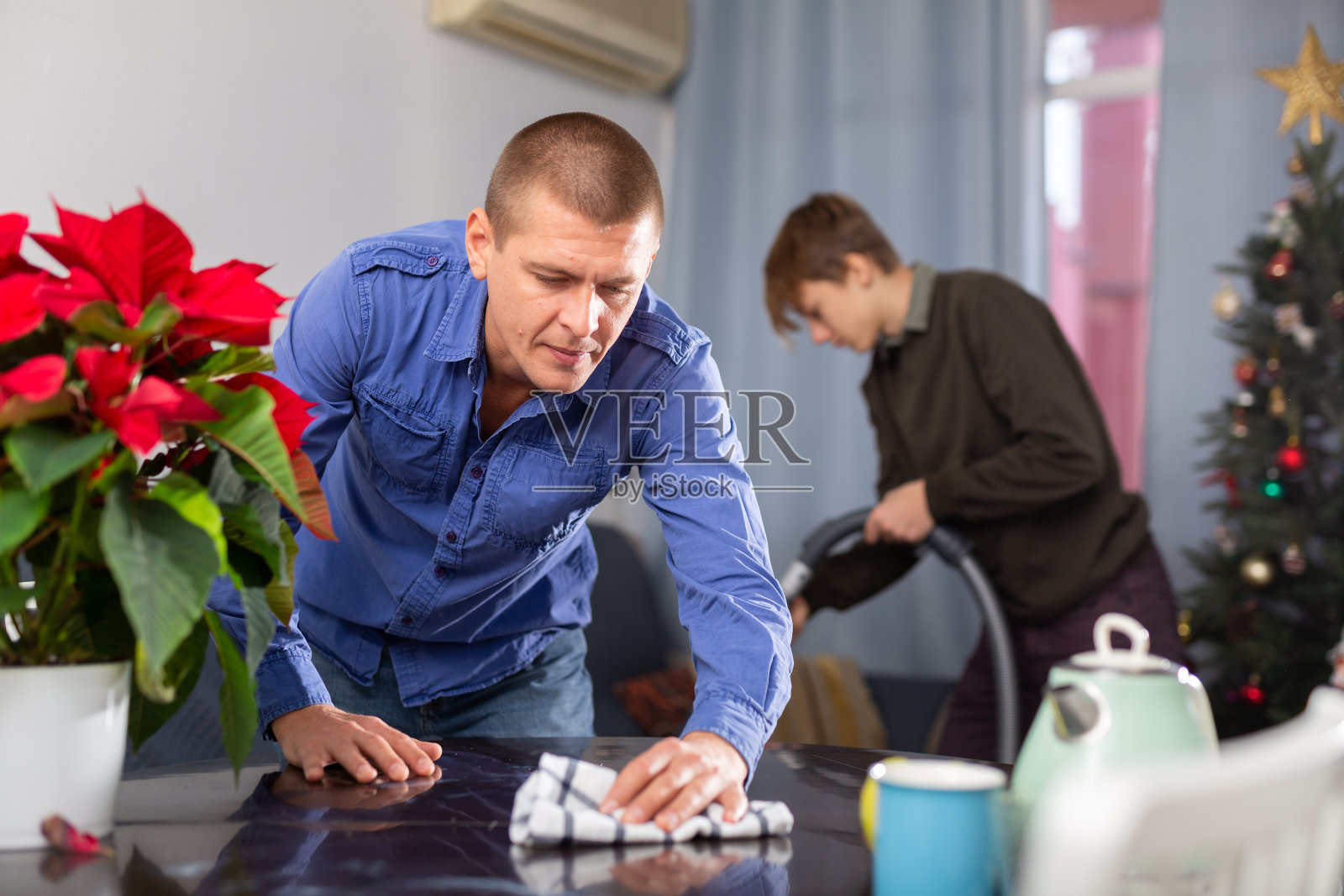 圣诞节前父子一起打扫房间照片摄影图片