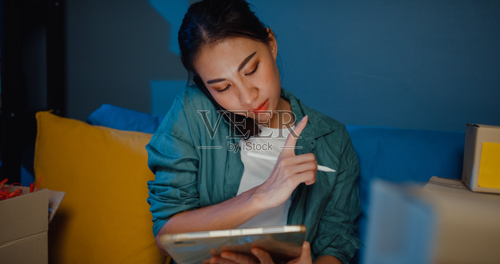 年轻的亚洲女售货员在网上商店打电话，并在晚上把订单送到客户家里。照片摄影图片