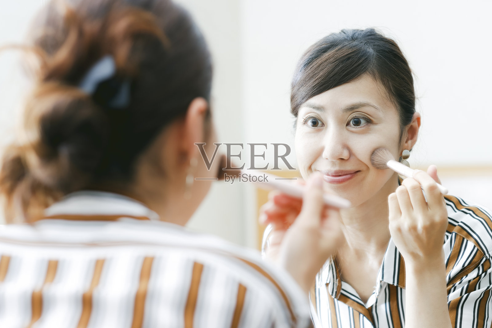 亚洲女人看着镜子和化妆照片摄影图片