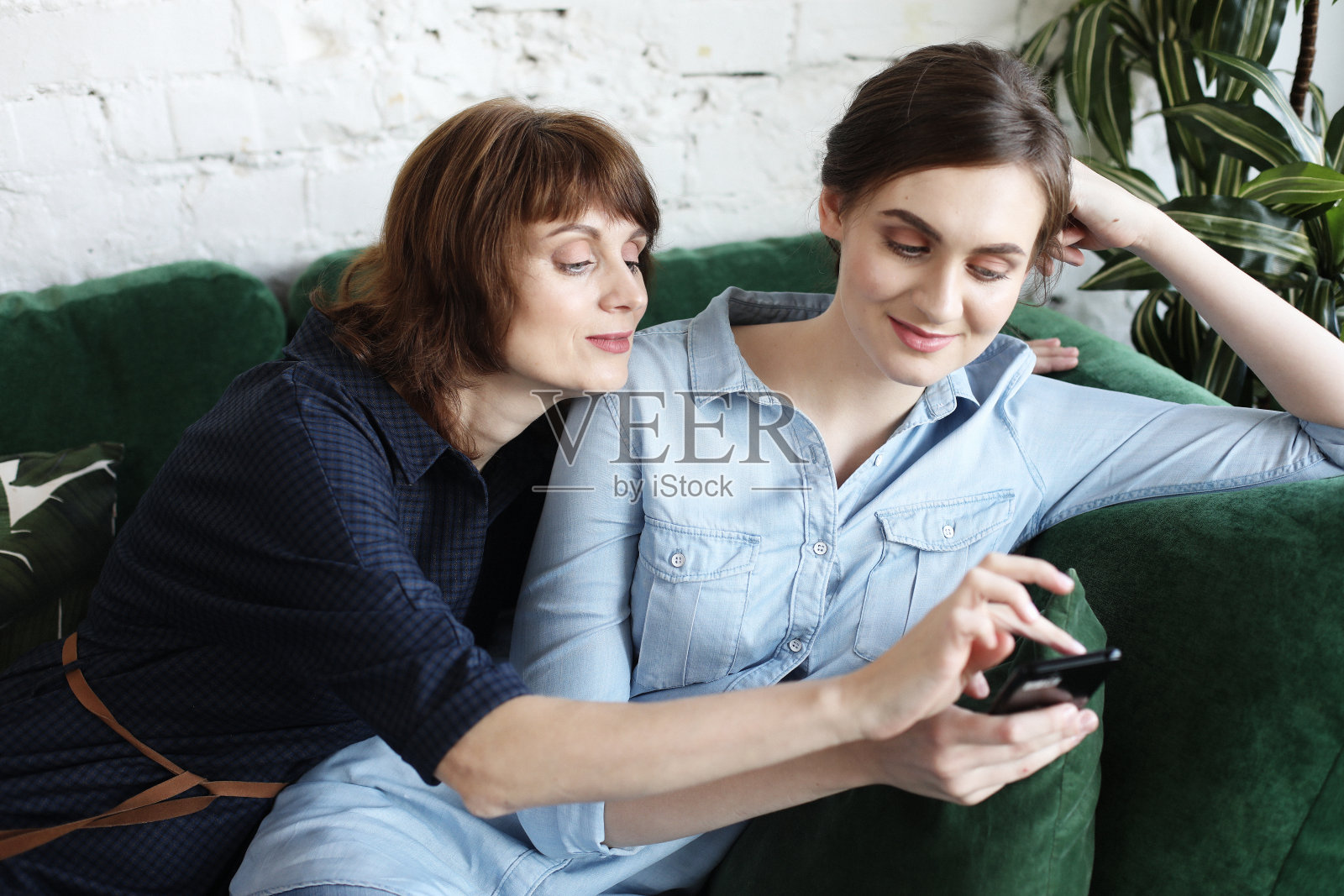 成熟的母亲和女儿用智能手机自拍照片摄影图片