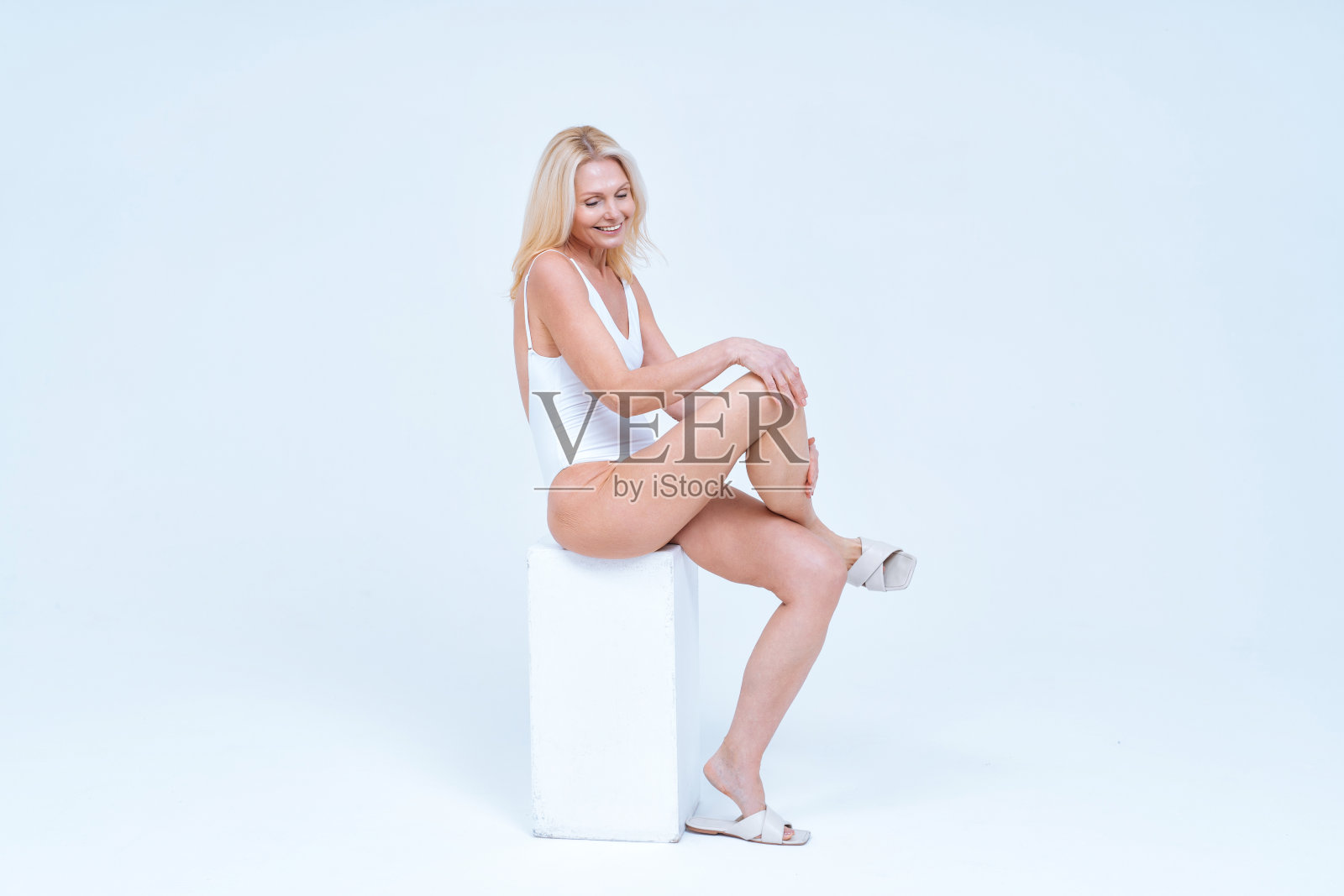 美丽的中年妇女在内衣摆姿势照片摄影图片