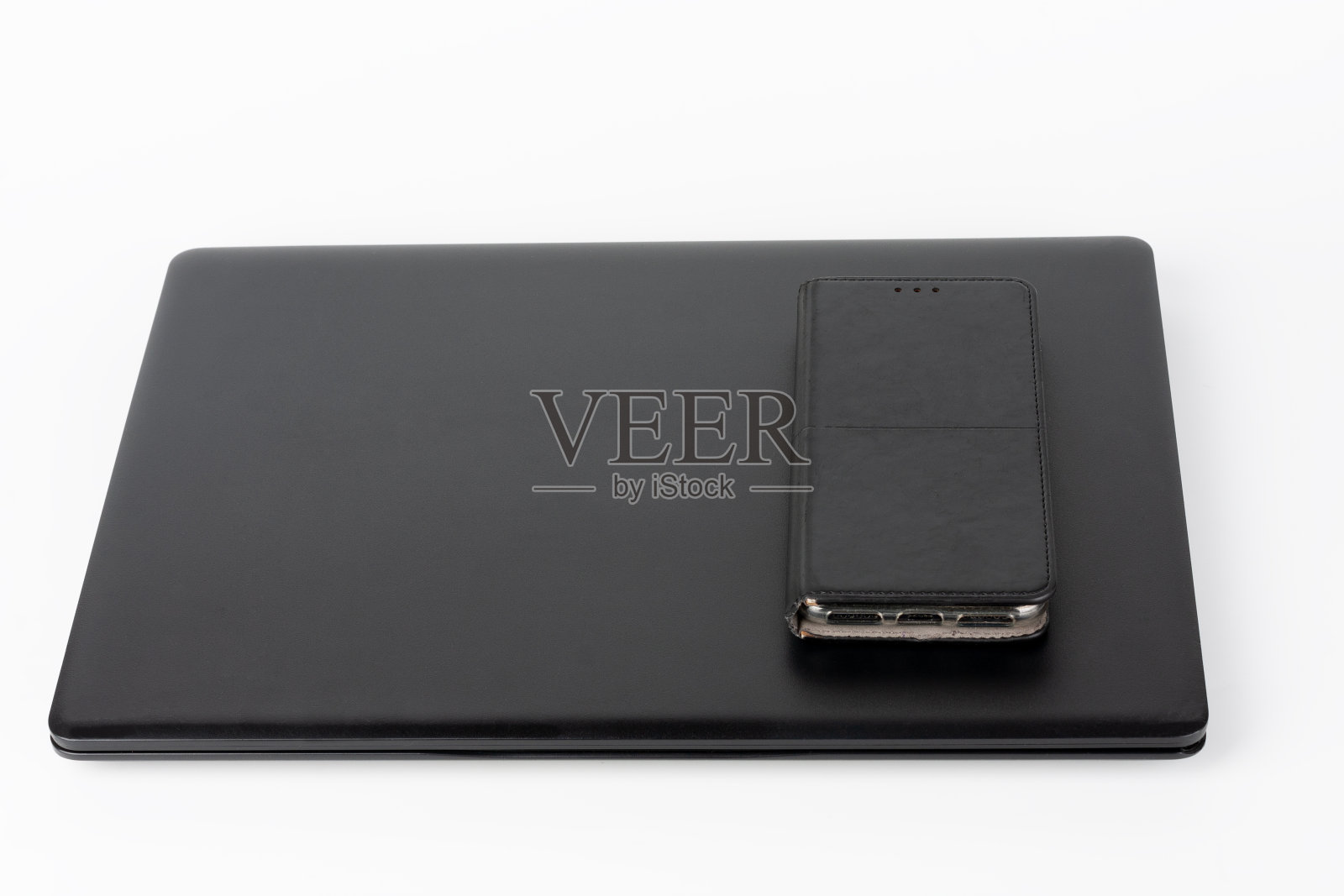 现代，新的办公室黑色笔记本电脑和触摸屏智能手机在皮套白色背景照片摄影图片