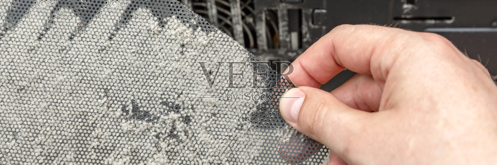 肮脏的电脑机箱。系统单元上有一层灰尘。是时候清理你电脑上的灰尘了。手里的电脑上的网眼灰蒙蒙的照片摄影图片