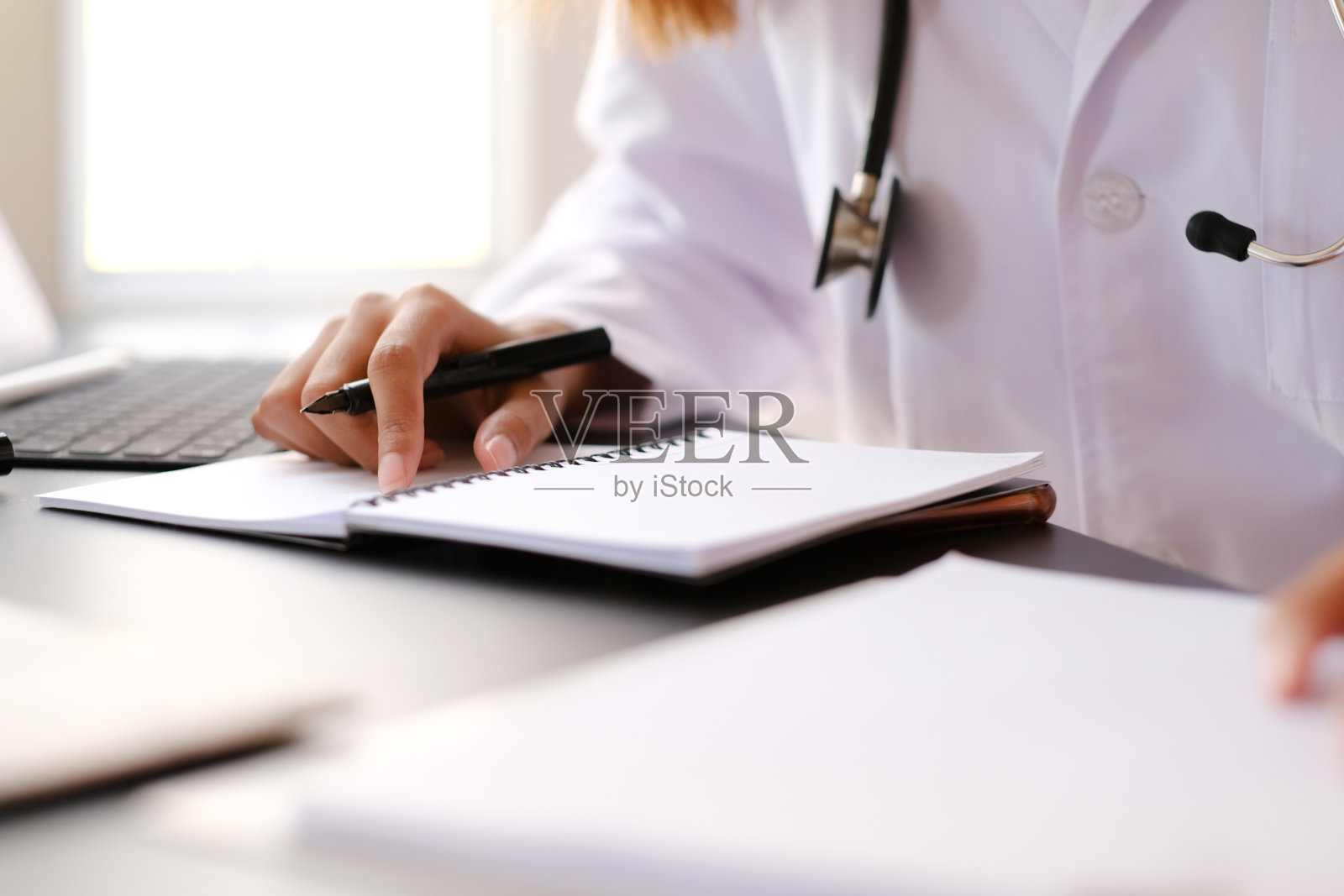 医生在医院的医生办公室工作。照片摄影图片