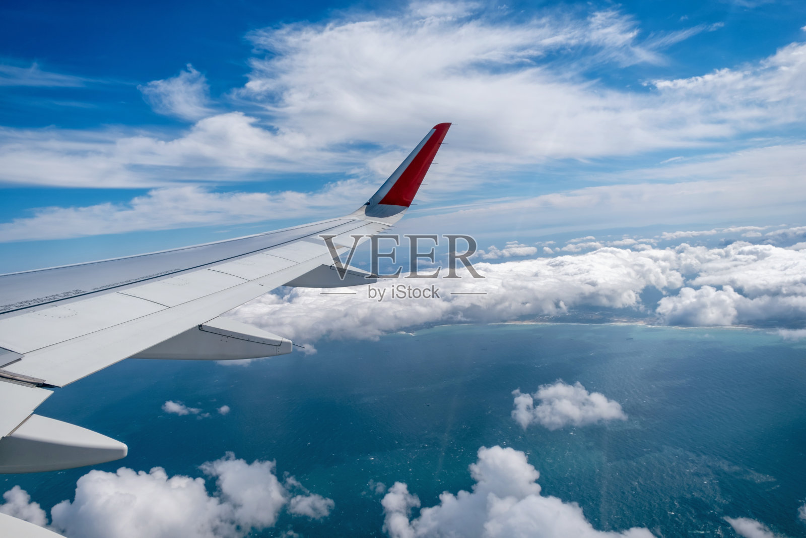 经典图像通过飞机窗口到机翼。在多云天气飞行俯瞰海面照片摄影图片