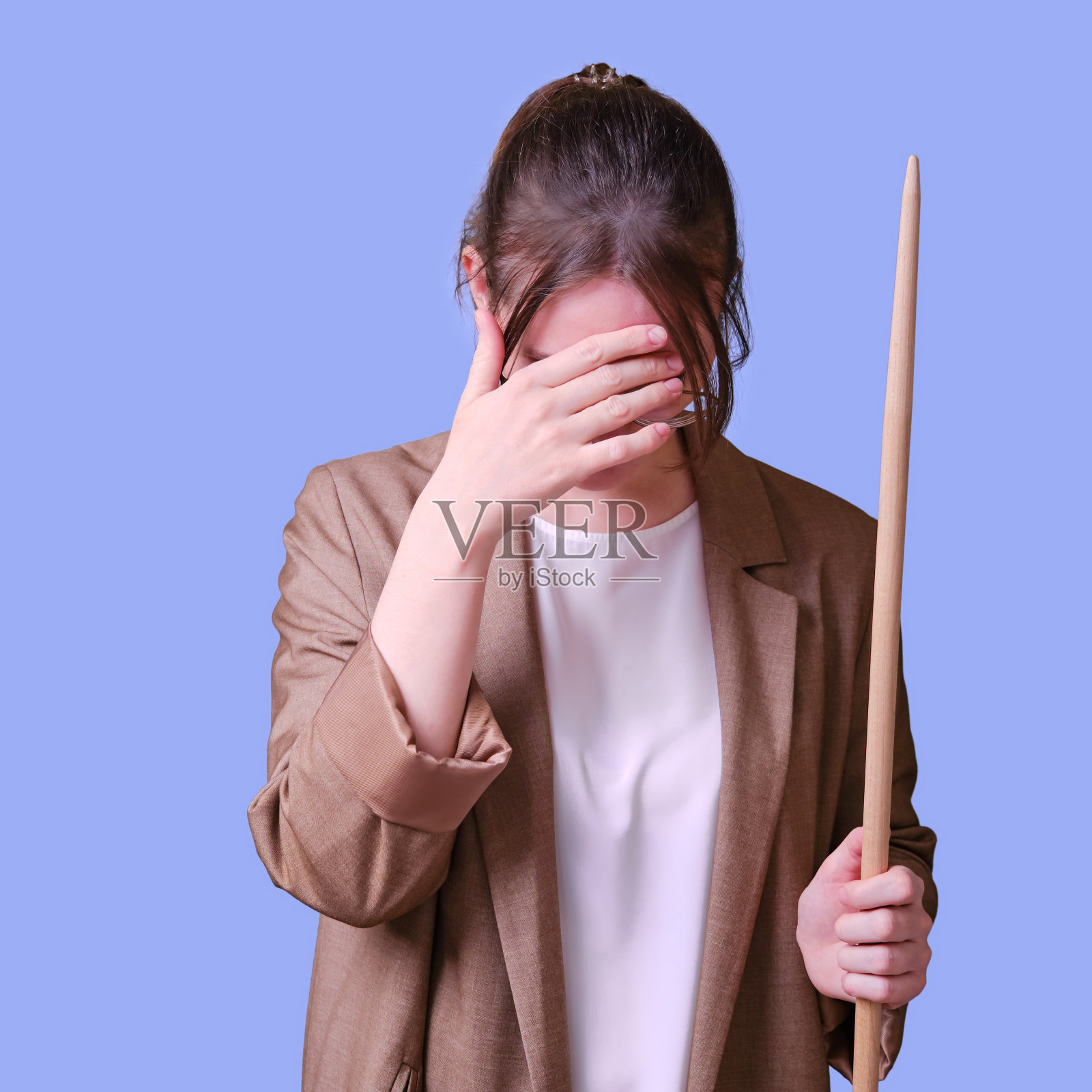 女教师头痛的工作室蓝色背景，复印空间照片摄影图片