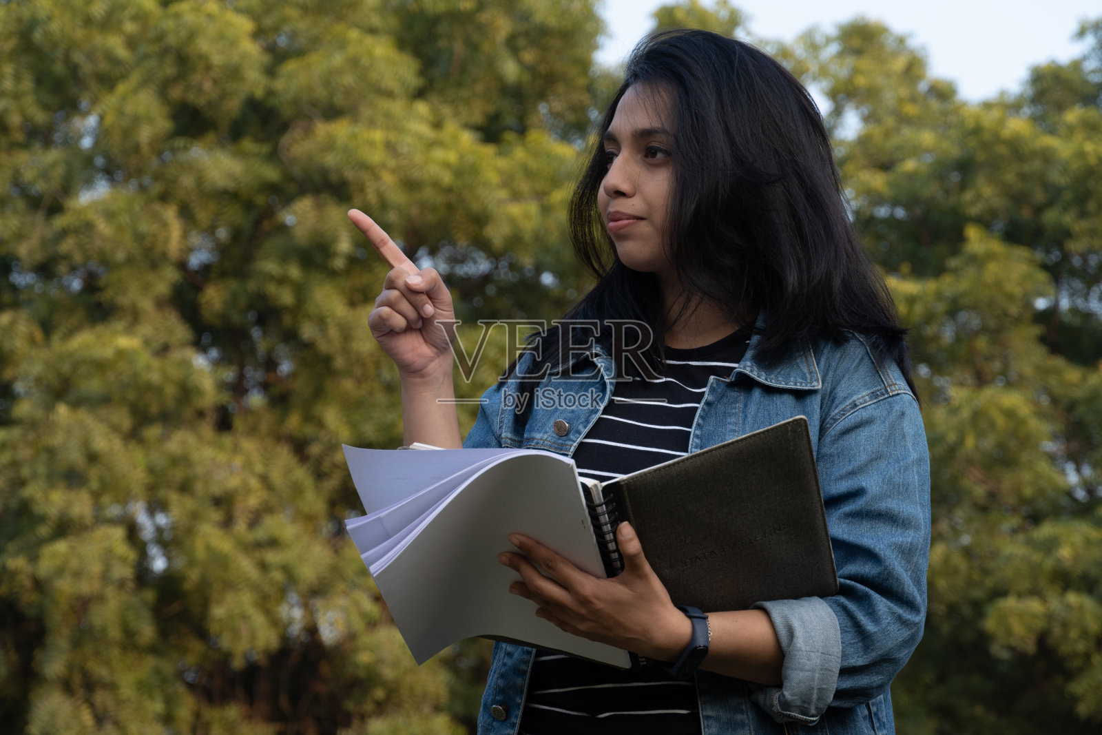 一名大学生拿着一些书照片摄影图片