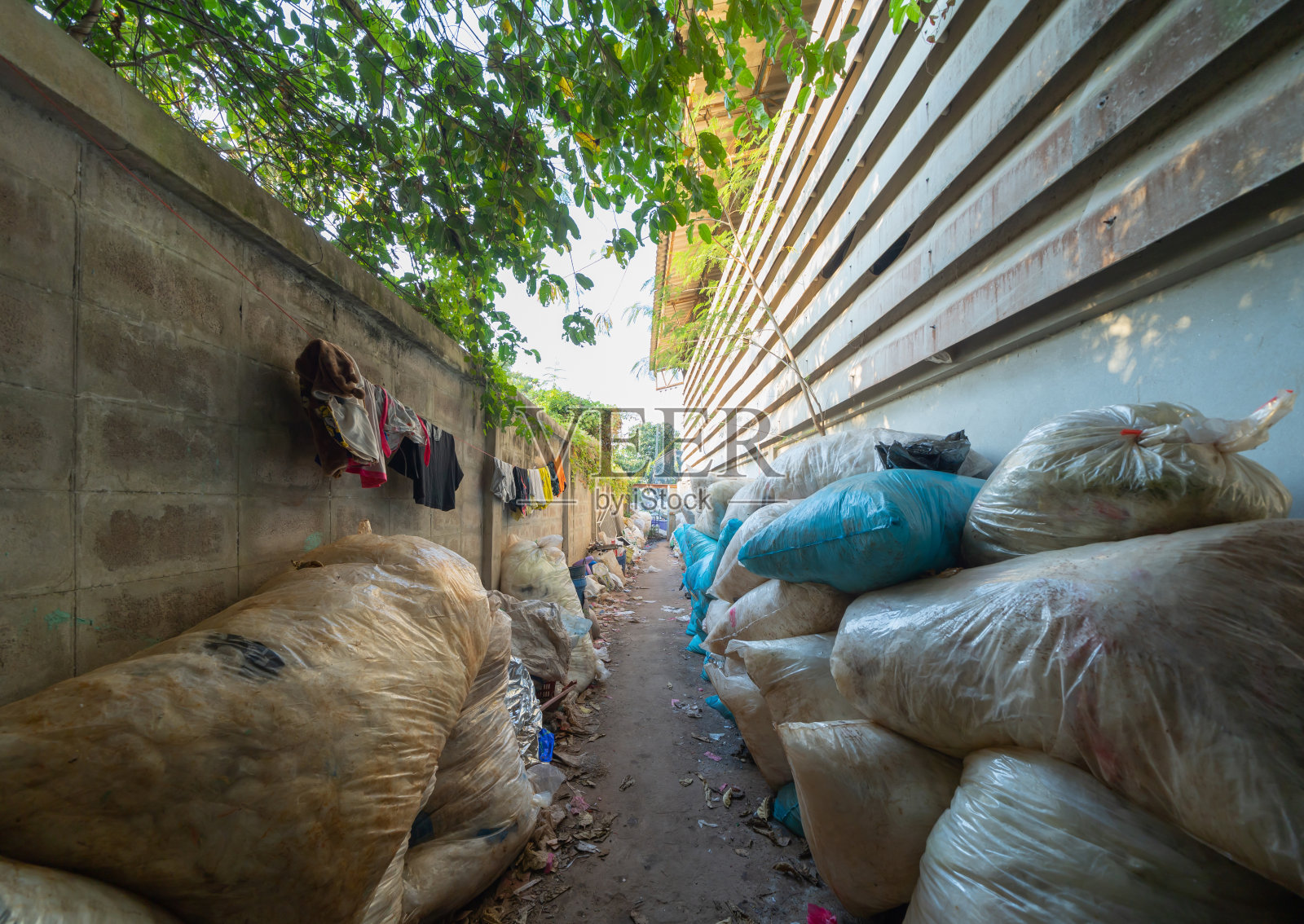 在城市环境污染概念中，工厂工业具有不同类型的堆积式大型垃圾场、塑料袋、瓶子和垃圾桶。照片摄影图片