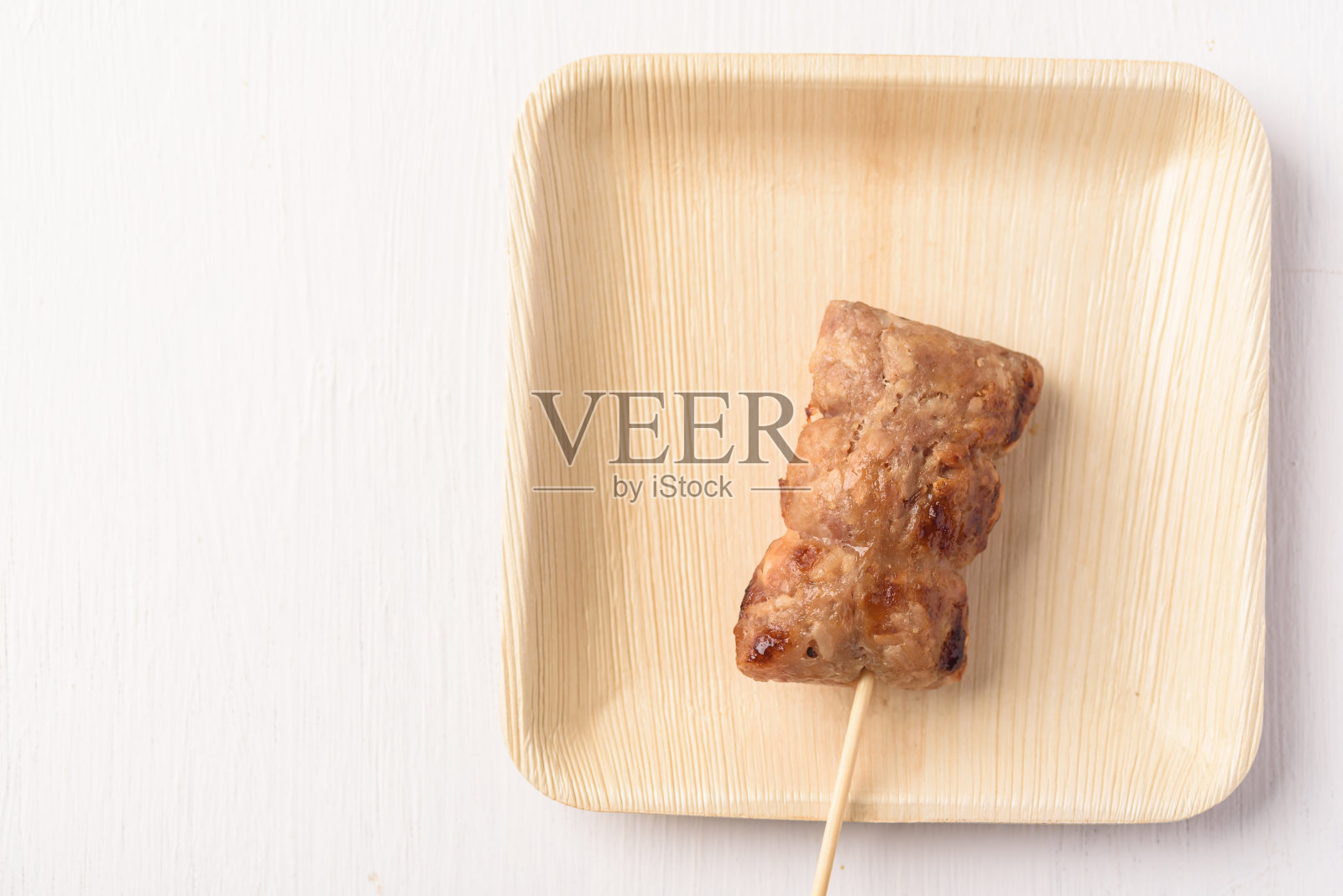 当地的街头小吃有一种酸味，是用发酵的猪肉末配米饭，再用木炭烤成的。照片摄影图片