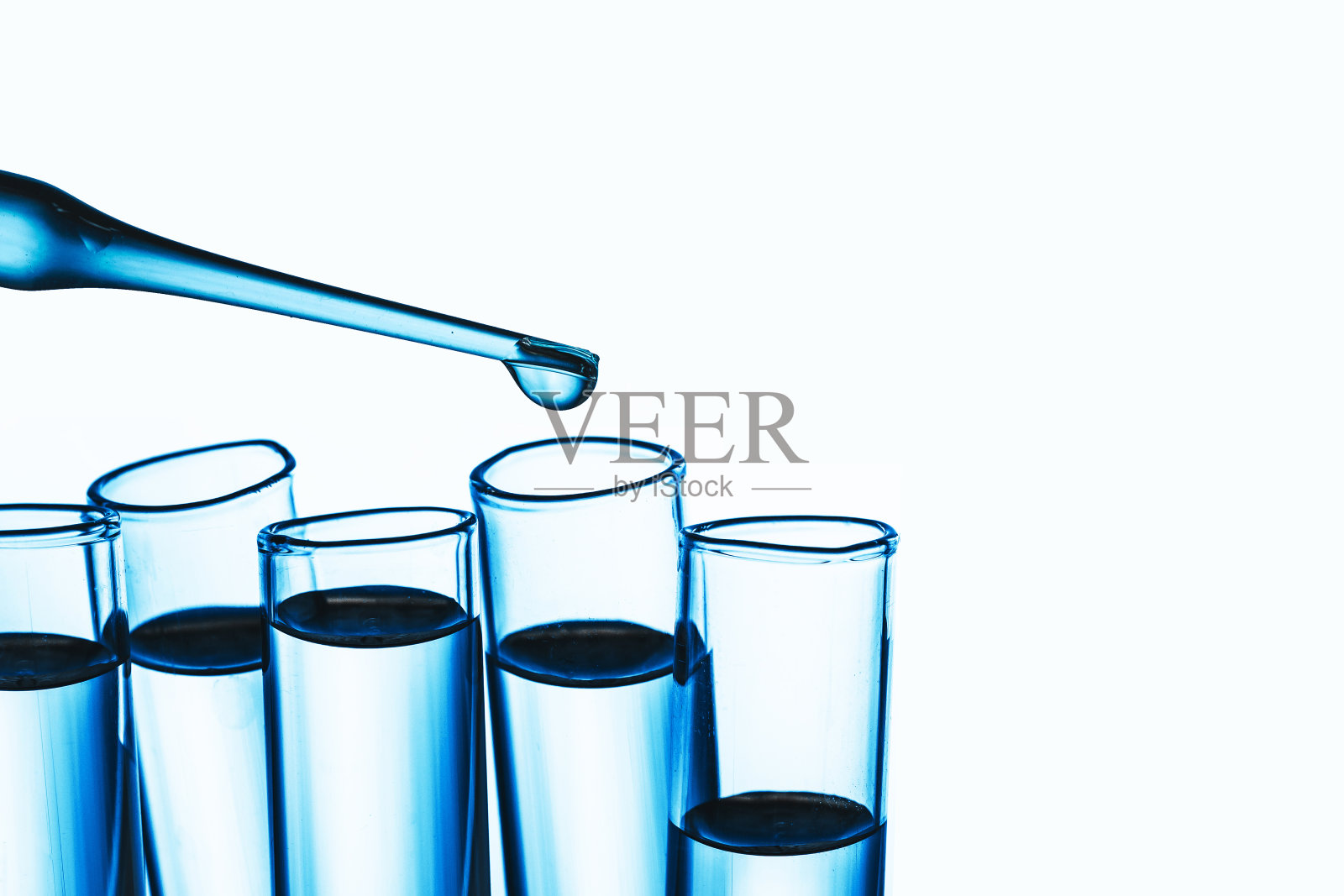 实验室的背景。蓝色的液体吸管。滴入玻璃烧瓶隔离。试管透明液体。病毒疫苗研究。照片摄影图片