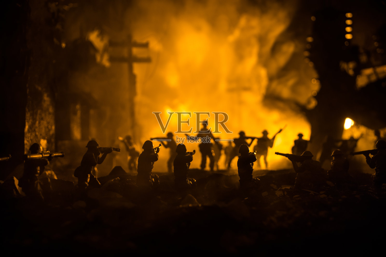 战争的概念。在战争雾天背景下的军事剪影战斗场景，世界大战士兵的剪影在阴天地平线下的夜晚。在废墟之城的战斗。有选择性的重点照片摄影图片