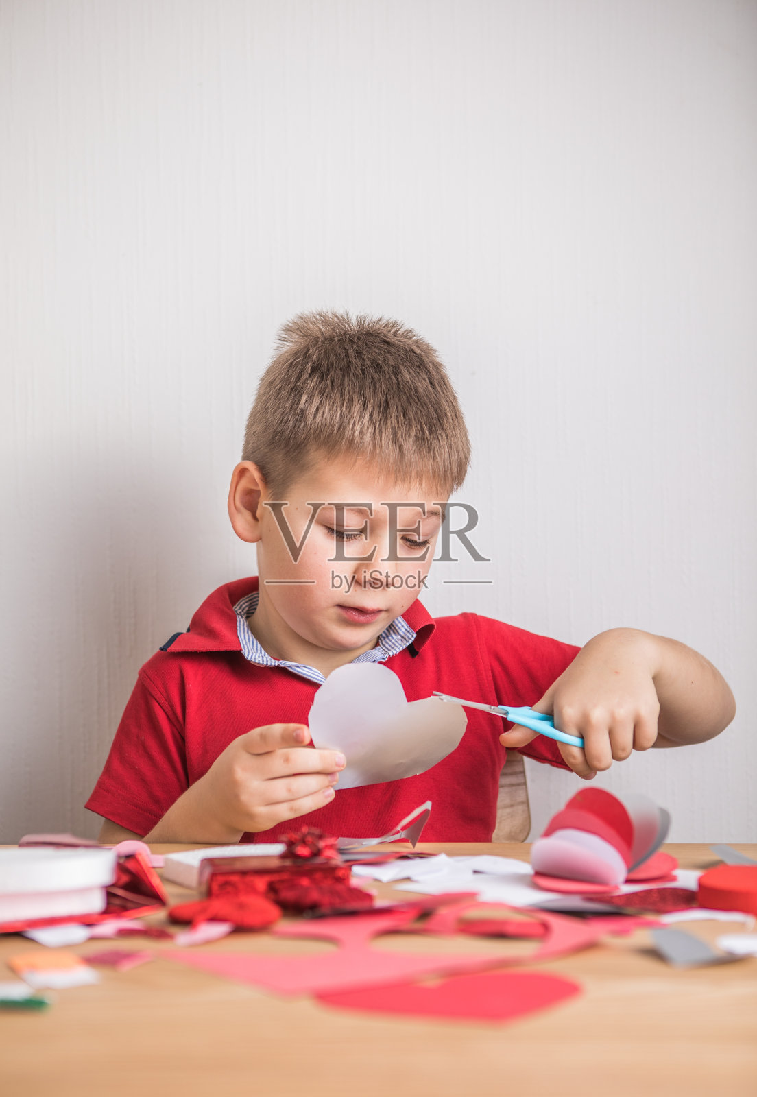 自制节日贺卡，红纸心形，爱的象征。小男孩做了母亲节，情人节，贺卡。爱好，儿童艺术观念，亲手送礼物，DIY儿童创意照片摄影图片