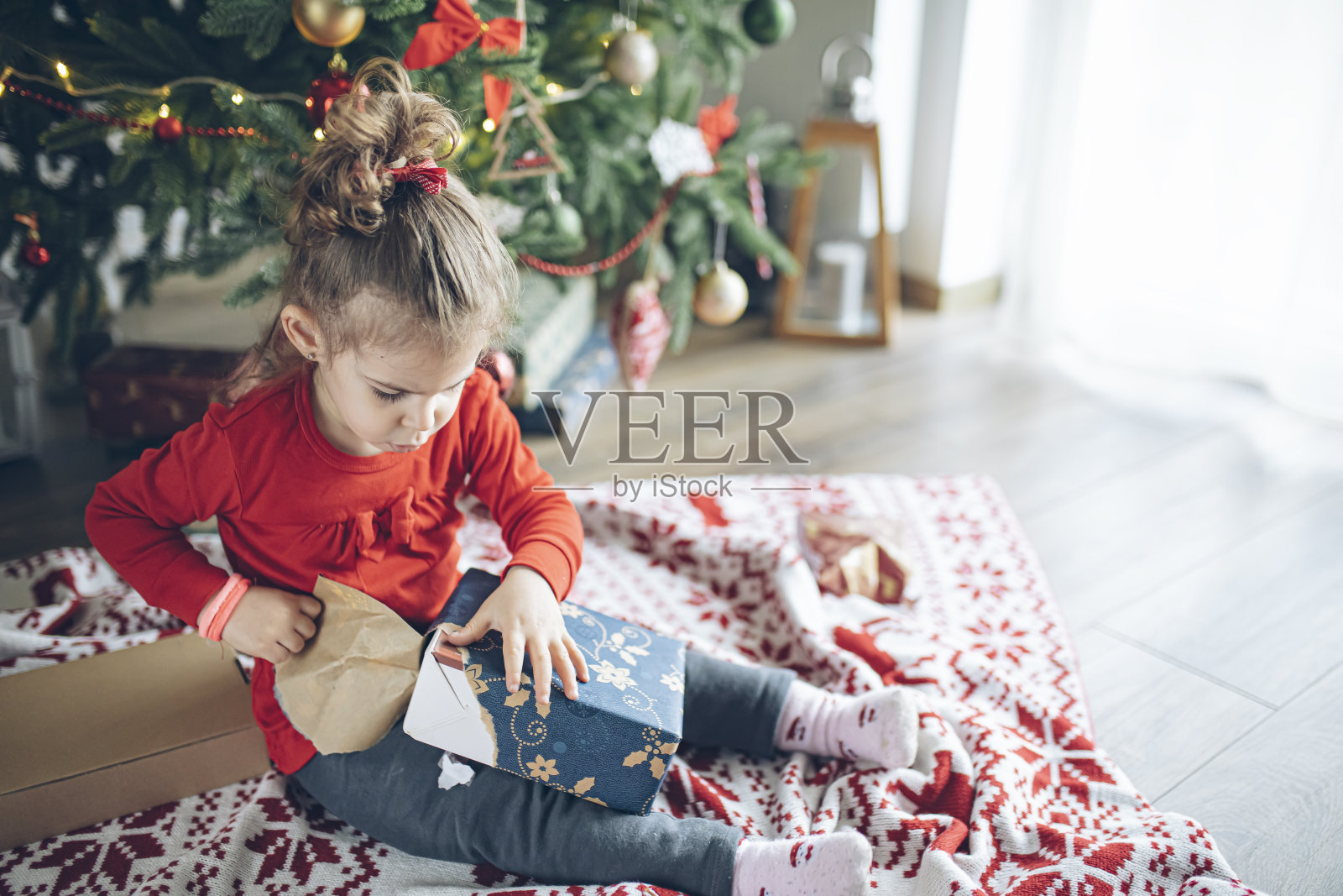 惊喜可爱的小女孩打开圣诞礼物照片摄影图片