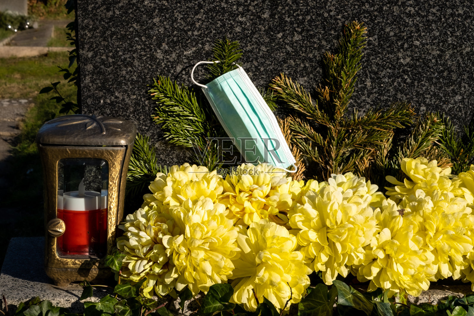 在墓地的蜡烛旁戴着面具照片摄影图片