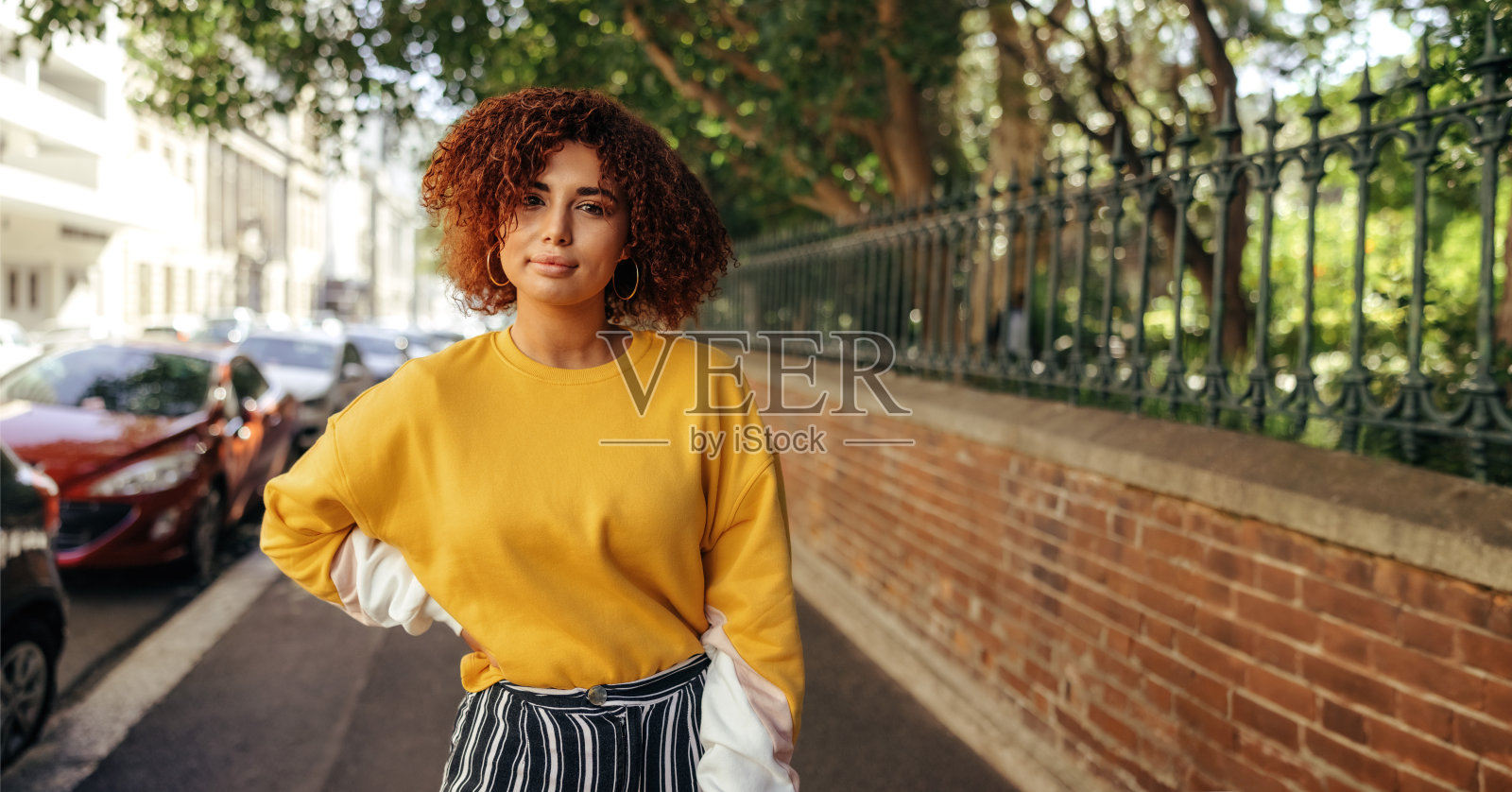 一个十几岁的女孩站在城市的人行道上照片摄影图片