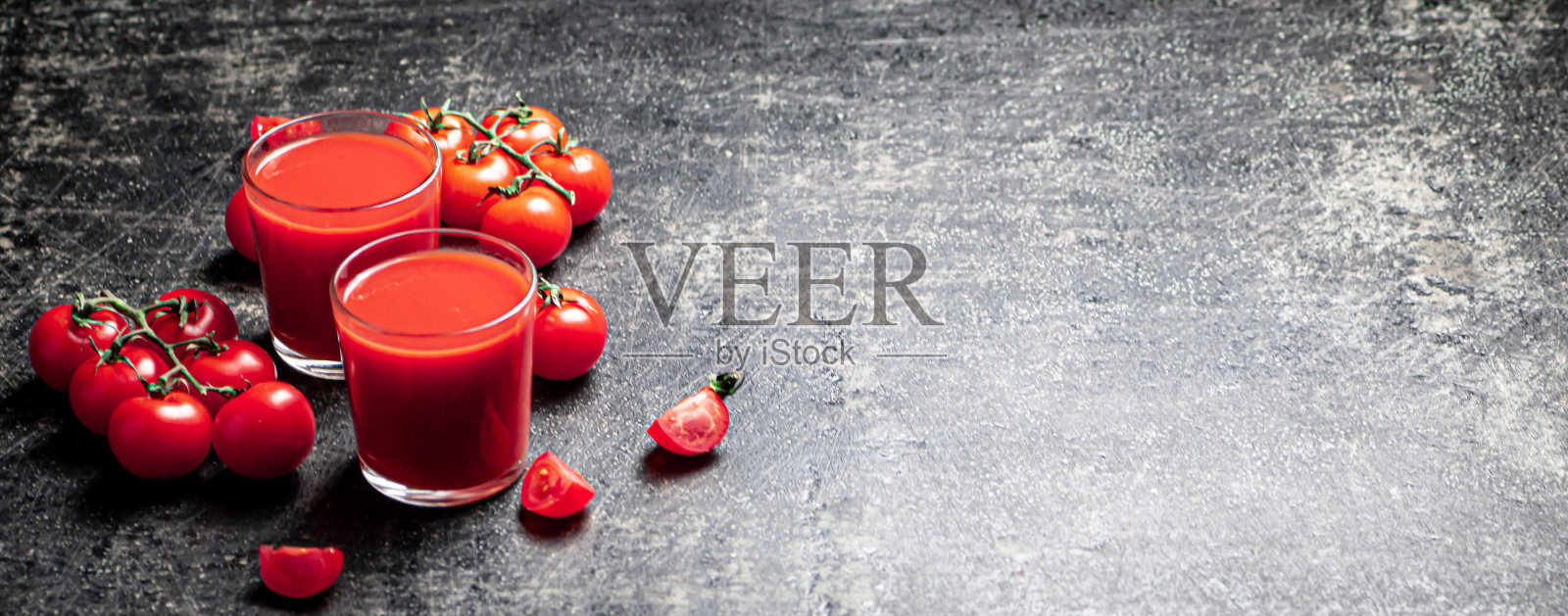 新鲜的番茄汁。在黑色的背景上。照片摄影图片