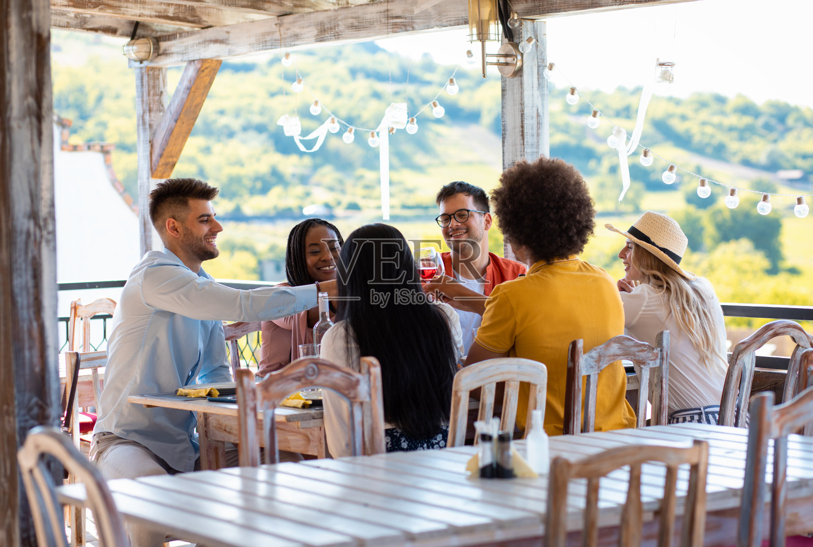 一群朋友聚在一起吃饭喝酒。照片摄影图片