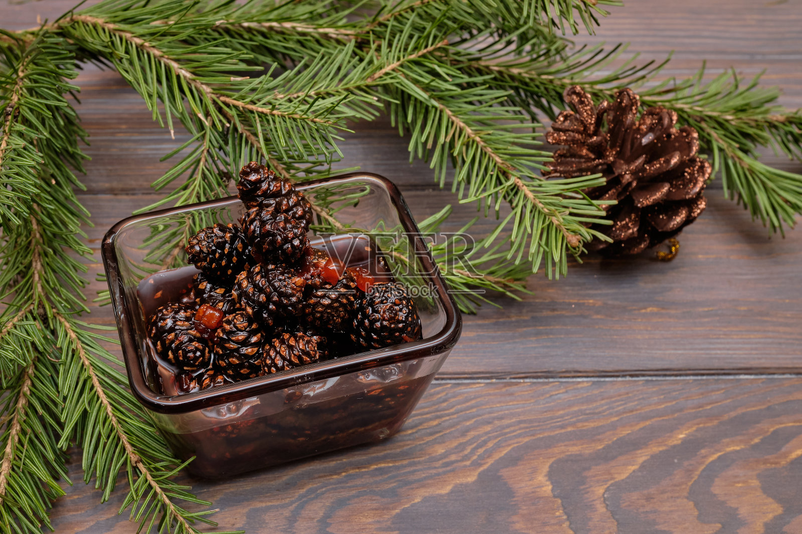 玻璃碗里的青松球果果酱。传统的西伯利亚甜点——嫩松果果酱。美味的果酱。照片摄影图片