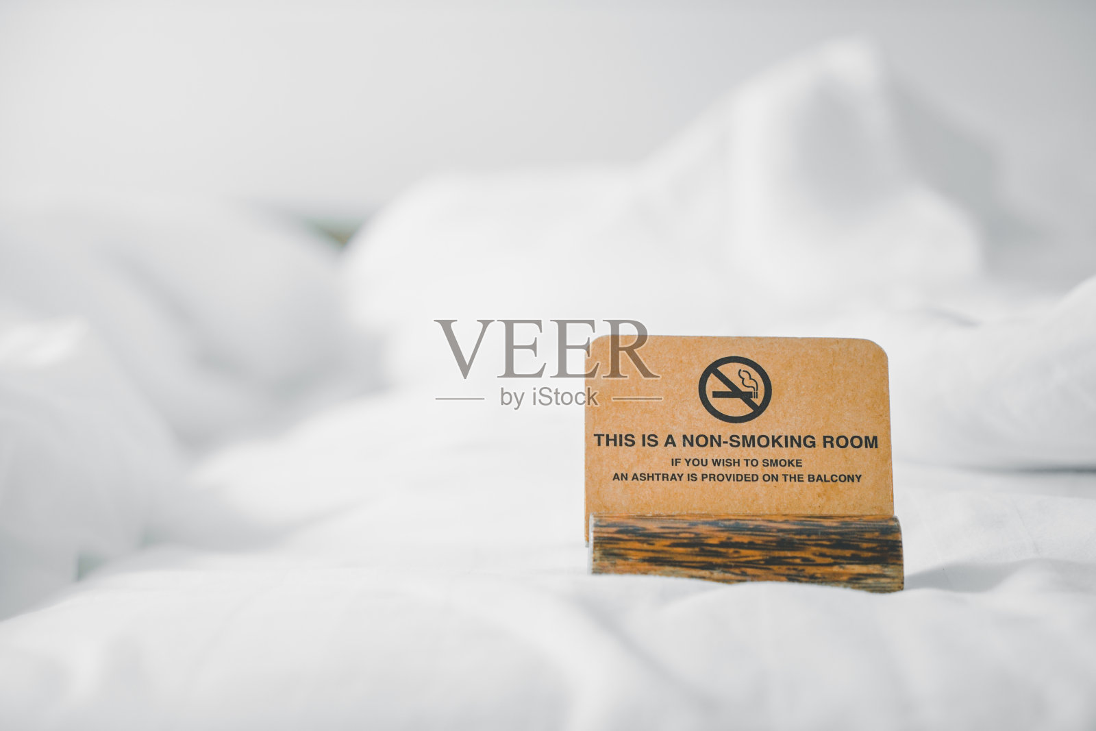 棕色的垃圾纸与非吸烟室模糊白色凌乱的床在卧室照片摄影图片