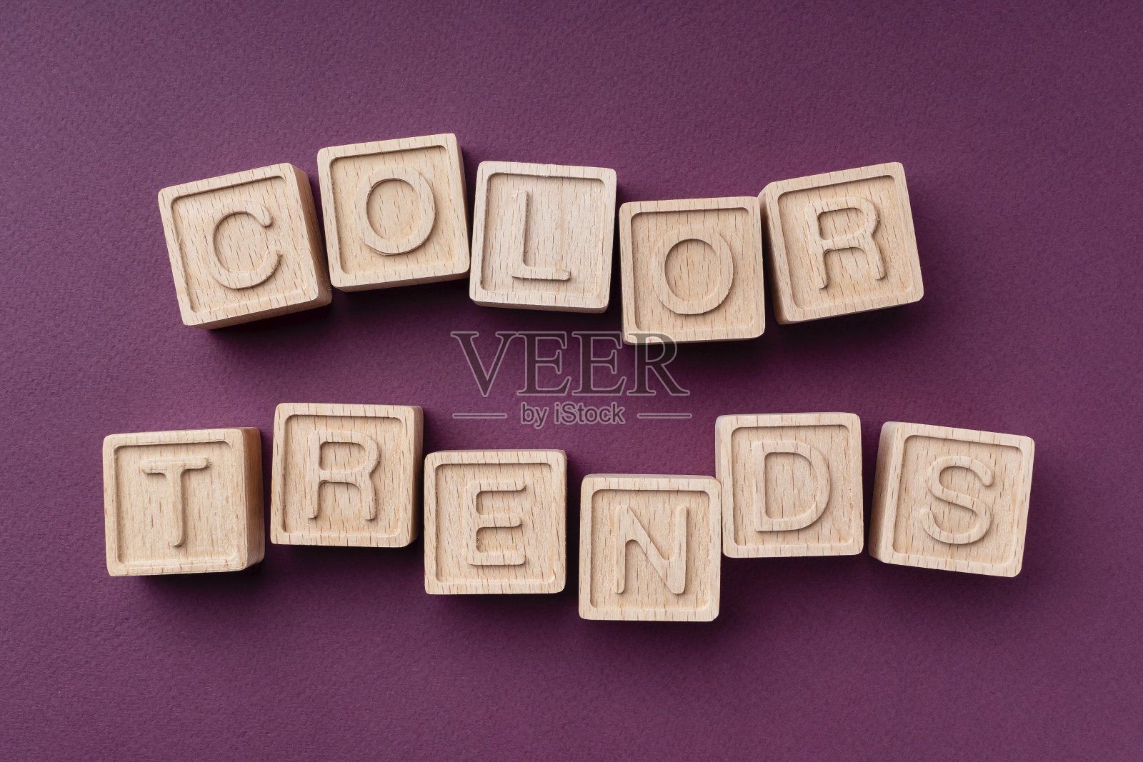 2022年的色彩趋势，平面，平铺，俯视图。碑文是由环保的木制立方体制成的。文字是这个季节的颜色，以酒红色为背景。明亮的概念趋势2022照片摄影图片