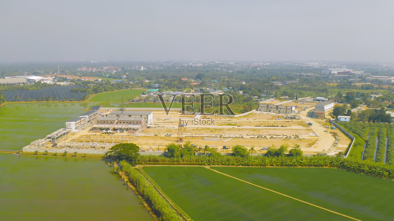 俯视图的干燥地面粗糙裂缝的土地与沙子的工厂建设工地。干旱图案纹理背景。照片摄影图片