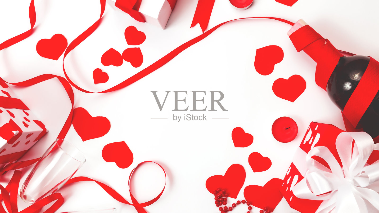 情人节框架。平放白色礼盒与红色丝带蝴蝶结，一瓶葡萄酒香槟葡萄酒，两杯在白色背景。情人节庆祝，情侣浪漫晚餐概念照片摄影图片