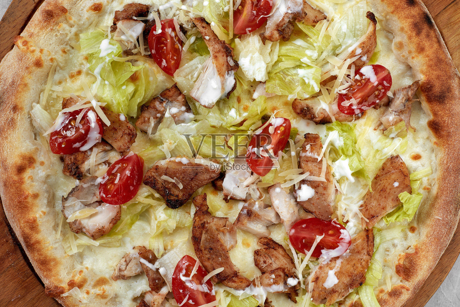 凯撒风格的美味披萨，配以白酱、鸡肉、帕玛森干酪、鸡蛋、圣女果和新鲜的生菜。餐厅披萨菜单与美味的披萨凯撒照片摄影图片