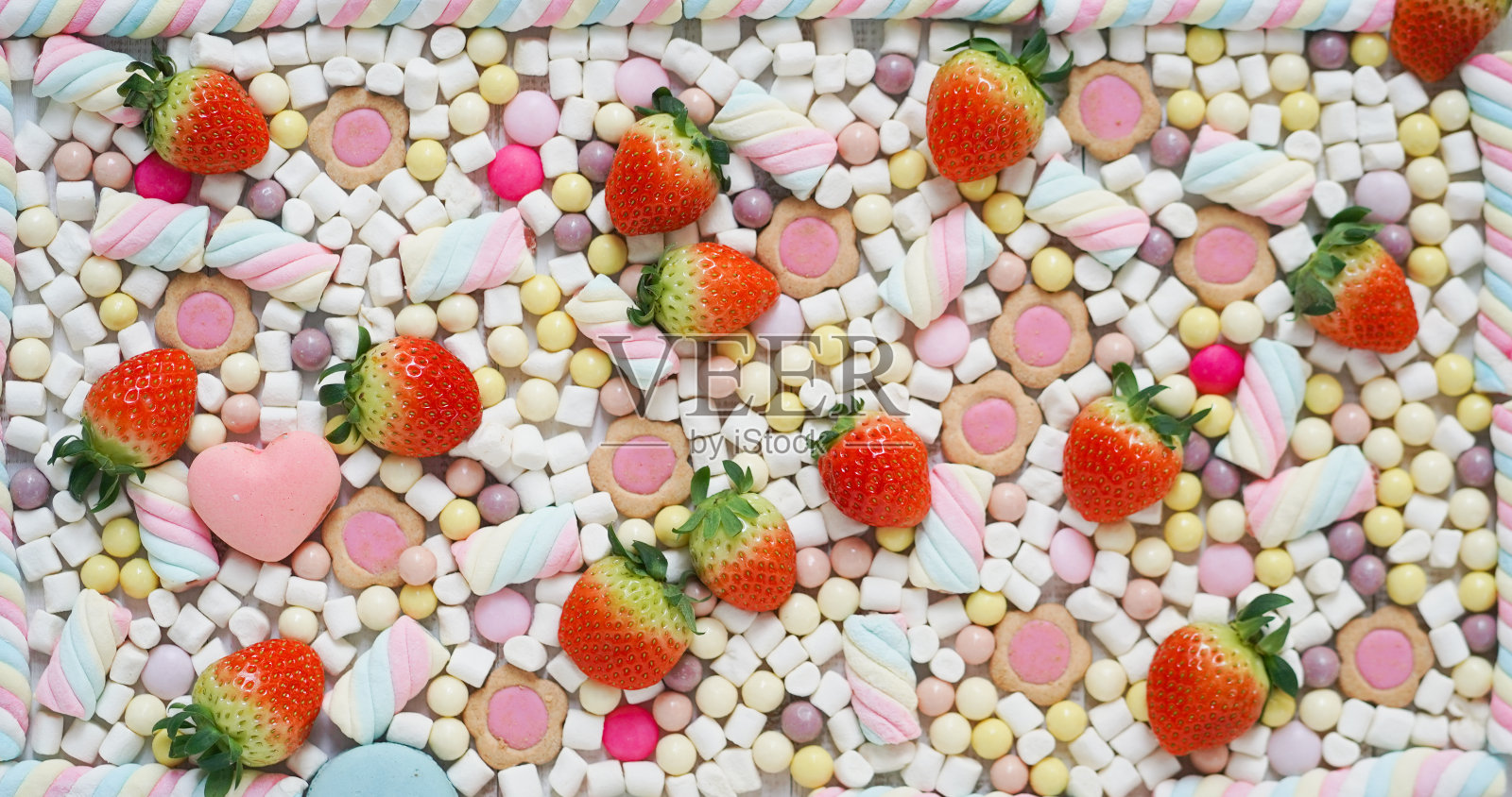 草莓和糖果。平面形象的新鲜草莓和许多柔和的甜包括棉花糖，马卡龙，巧克力和糖果。食品模式的背景。照片摄影图片
