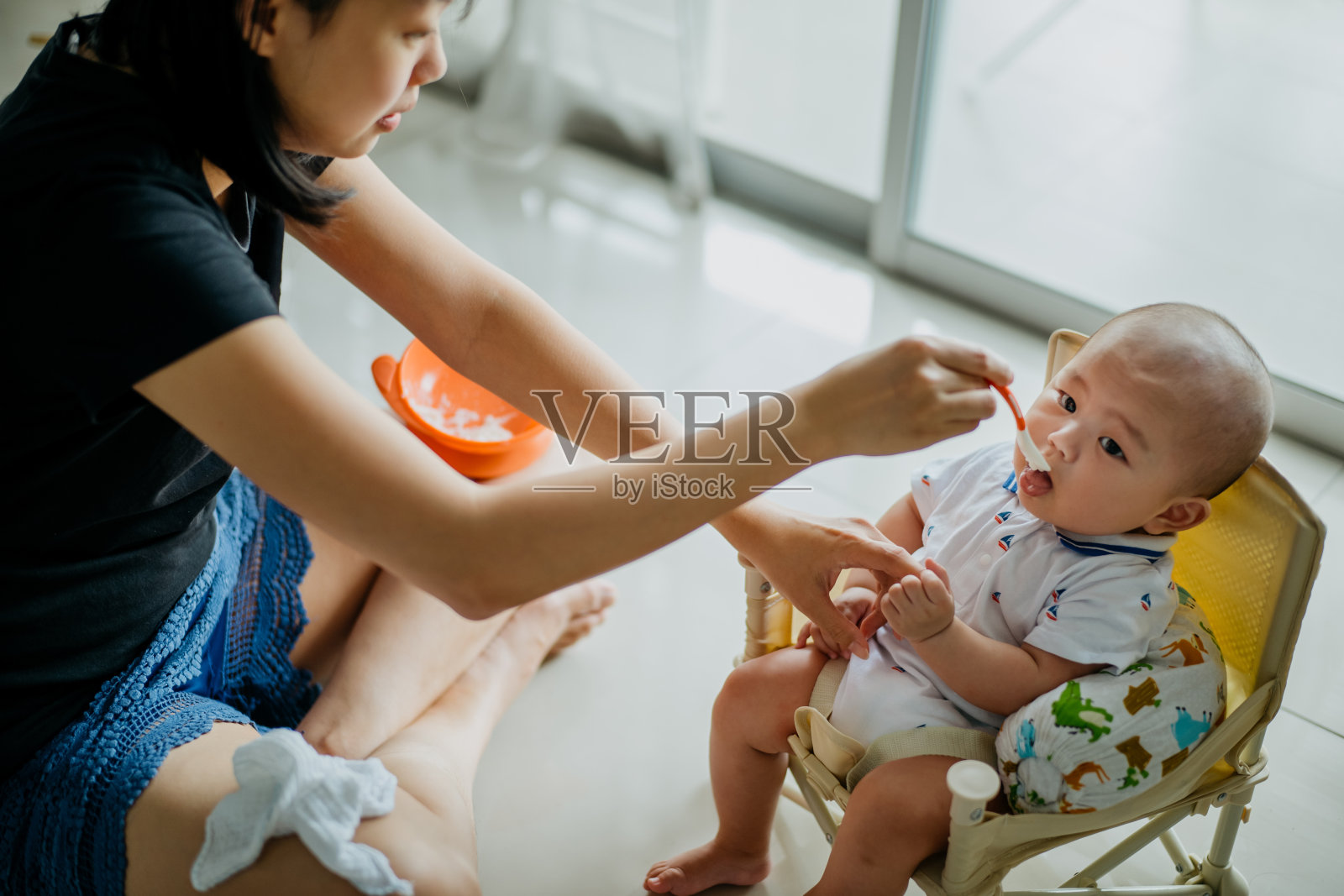 母亲用勺子喂她的婴儿照片摄影图片
