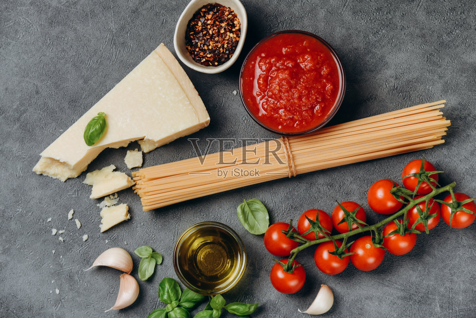 番茄酱意大利面。意大利菜的背景。生意大利面或通心粉，帕尔马干酪，橄榄油，香料，罗勒，番茄酱和新鲜番茄。俯视图照片摄影图片