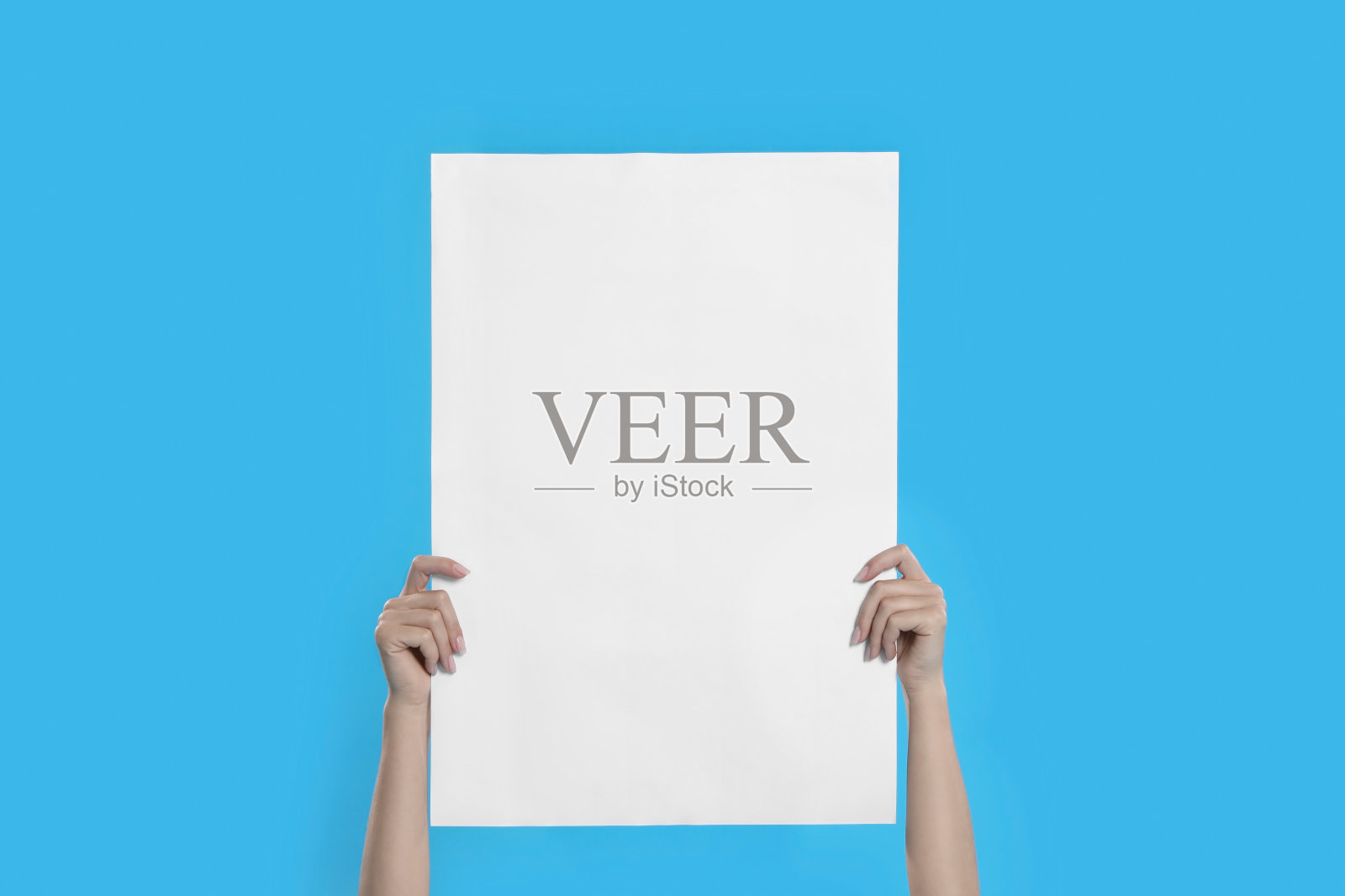 女人拿着蓝色背景的空白海报，特写照片摄影图片